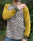 Organic cotton long sleeve shirt, undyed torso with yellow geometric striped sleeves, detail view of fabric.
