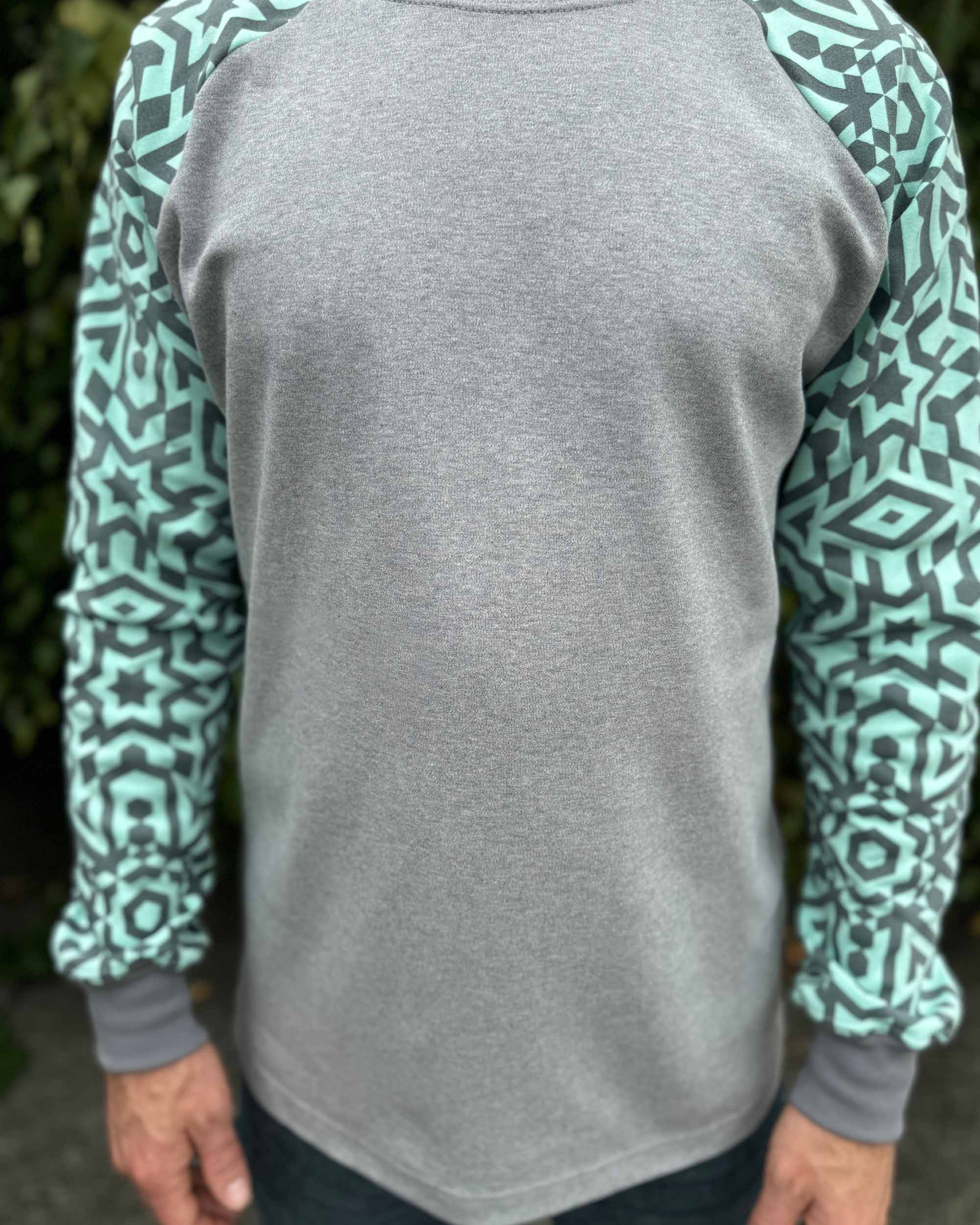Organic cotton long sleeve shirt, grey with mint geometric sleeves, detail view of fabric.
