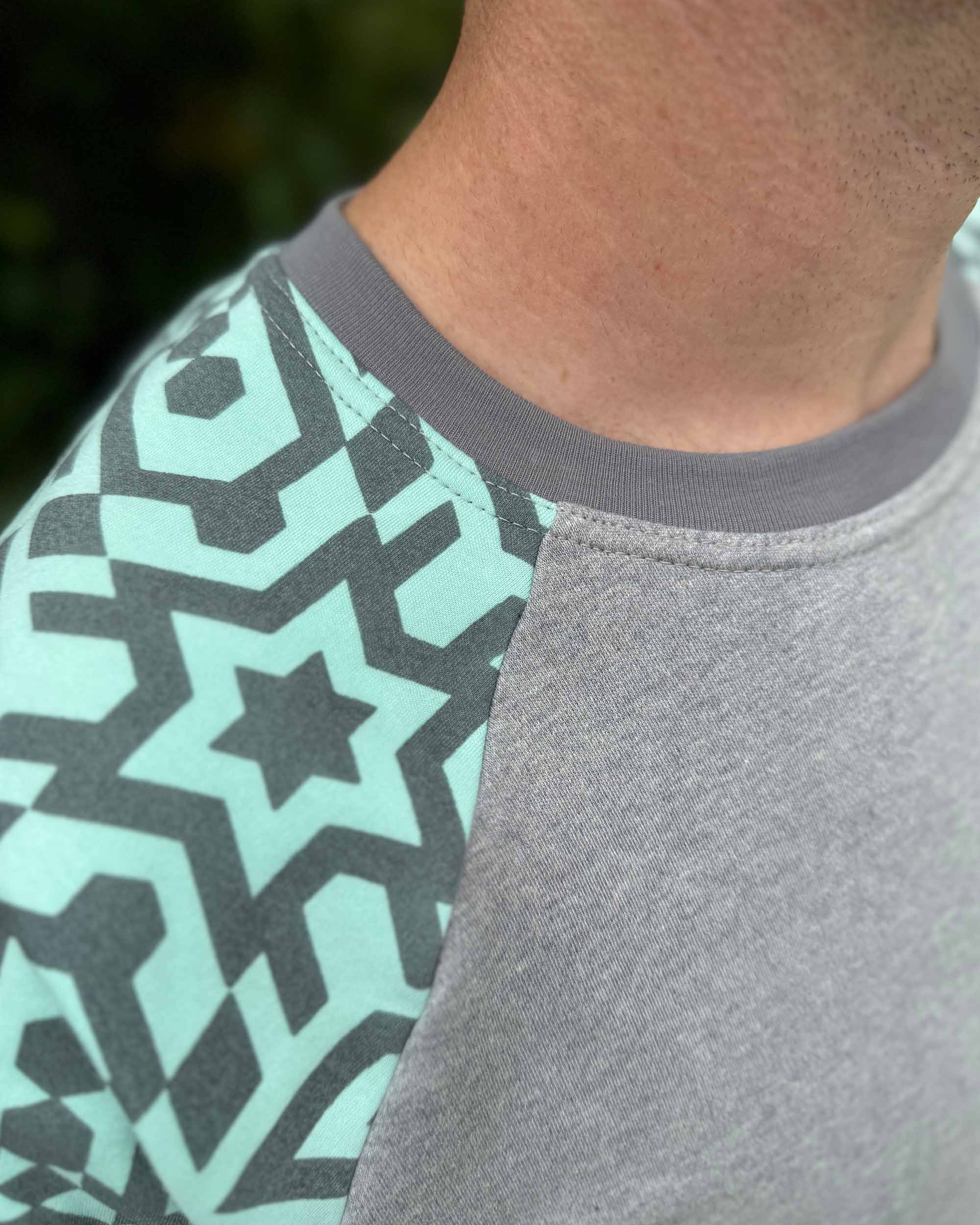 Organic cotton long sleeve shirt, grey with mint geometric sleeves, detail view of stitching.