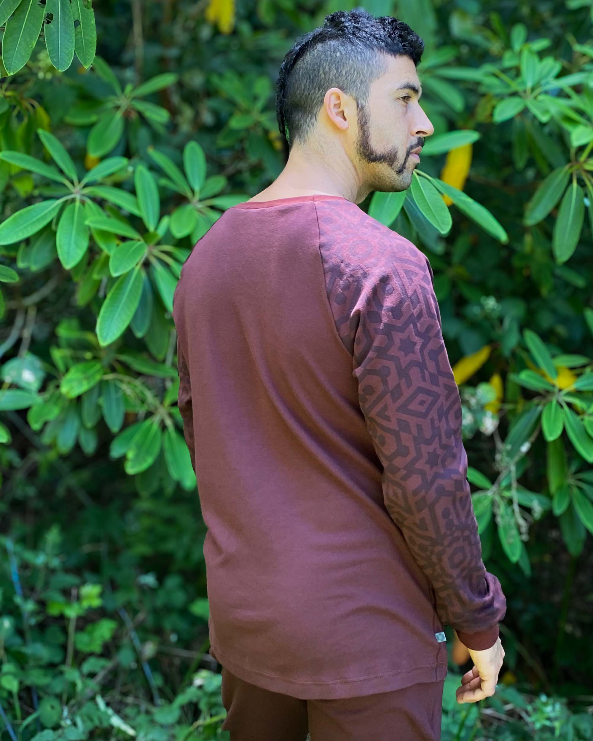 Organic cotton long sleeve shirt, brown with geometric sleeves, back side view on model.