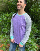 Organic cotton long sleeve shirt, lavender torso with grey geometric sleeves, left side view on model.