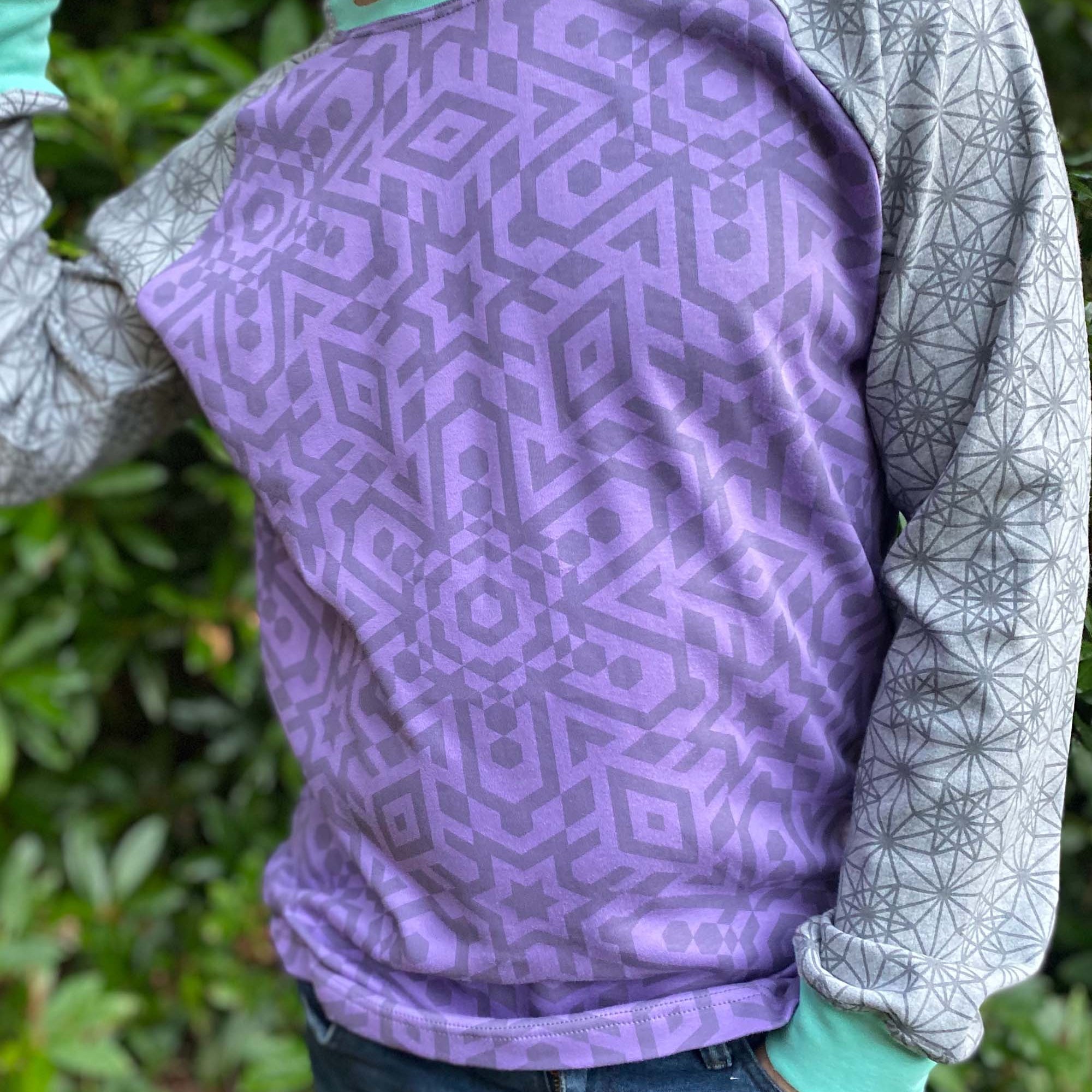 Organic cotton long sleeve shirt, lavender torso with grey geometric sleeves, detail view of fabric.