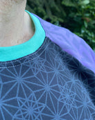 Organic cotton long sleeve shirt, black with lavender geometric sleeve print, detail view of stitching.