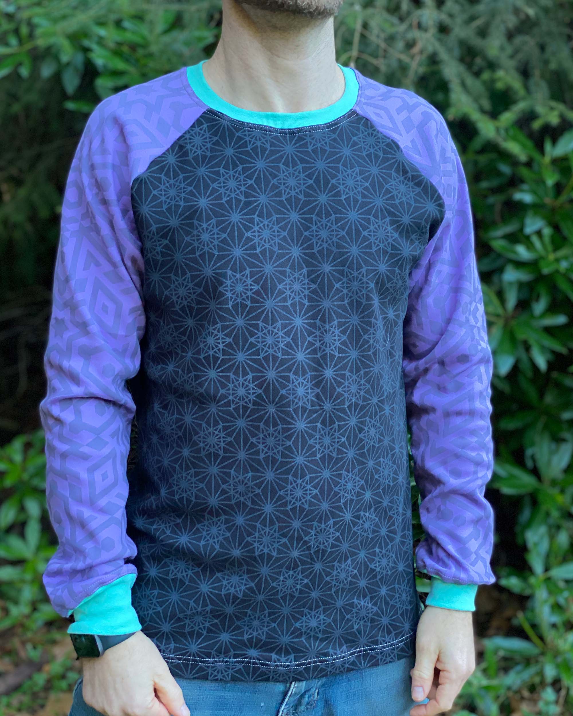 Organic cotton long sleeve shirt, black with lavender geometric sleeves, front view on male model.