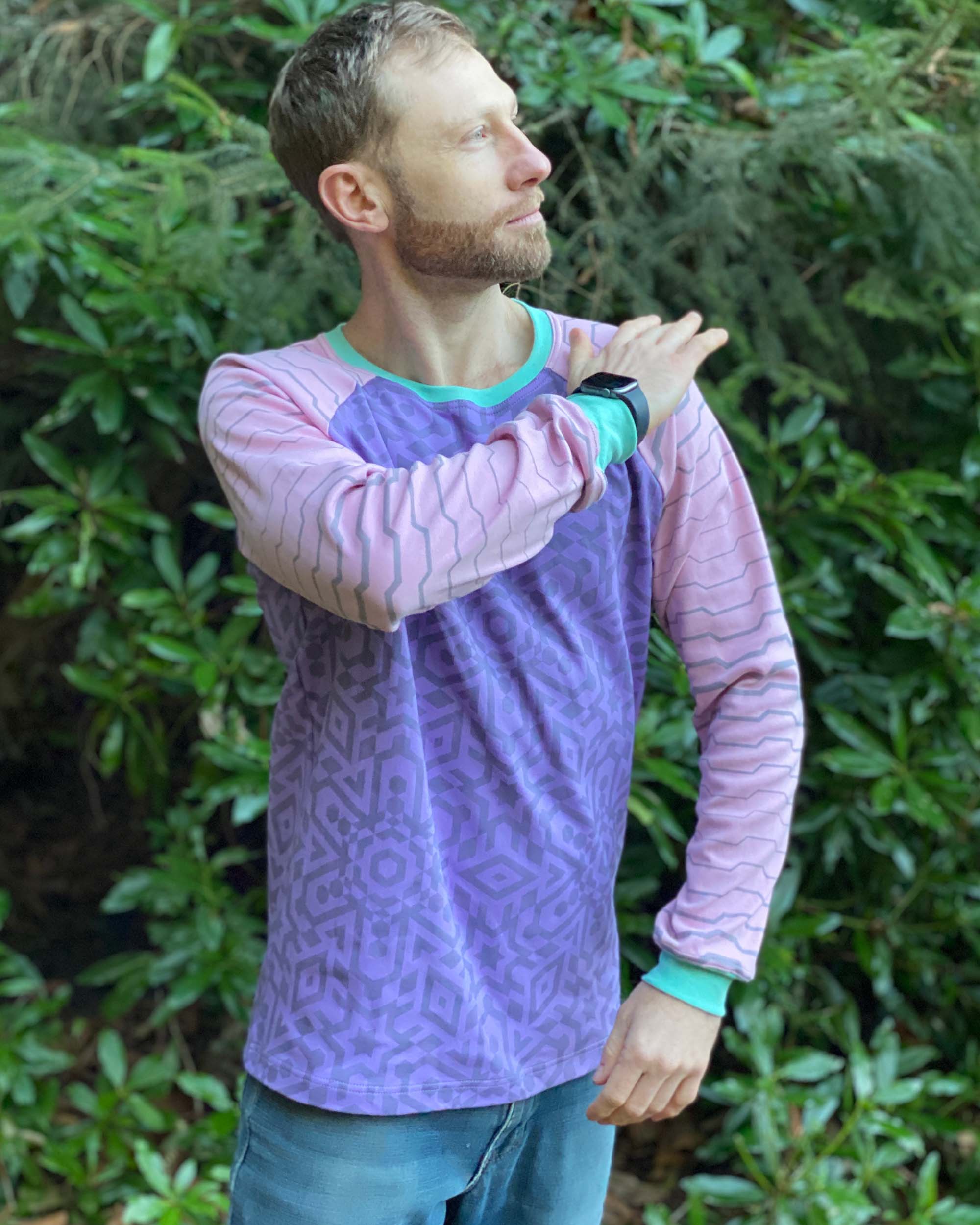 Organic cotton long sleeve shirt, lavender with pink geometric striped sleeves, front view on male model.