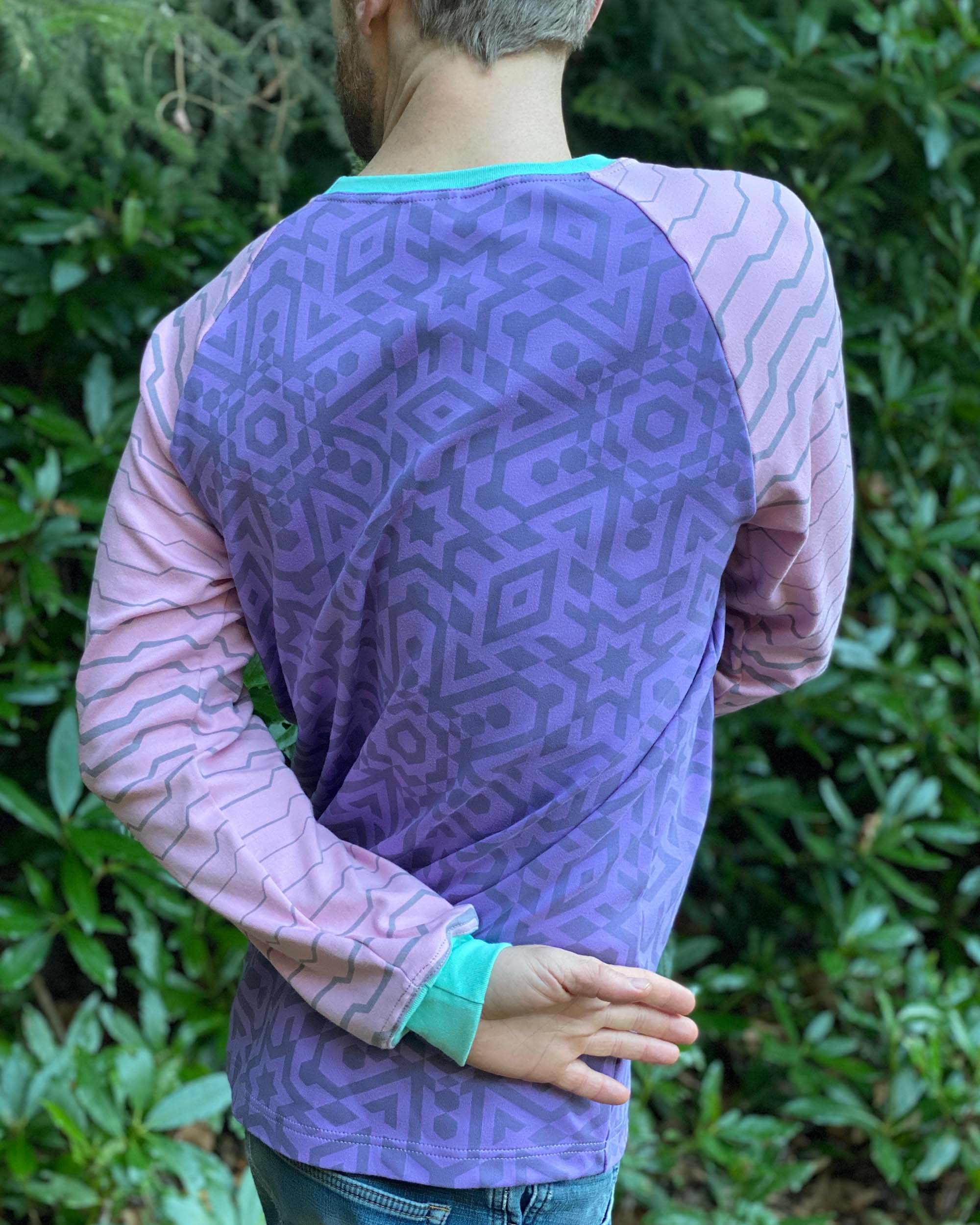 Organic cotton long sleeve shirt, lavender with pink geometric striped sleeves, back view on model.
