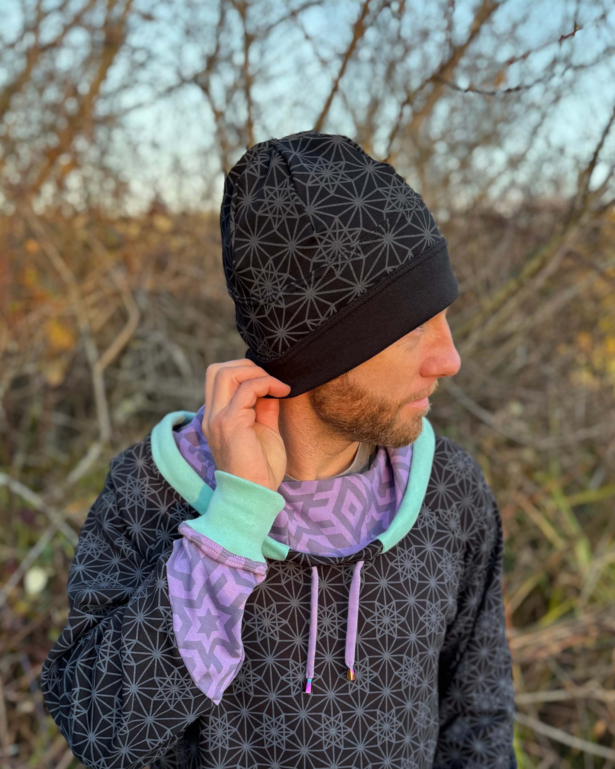 Organic cotton beanie, black fabric with geometric print, right side on male model.