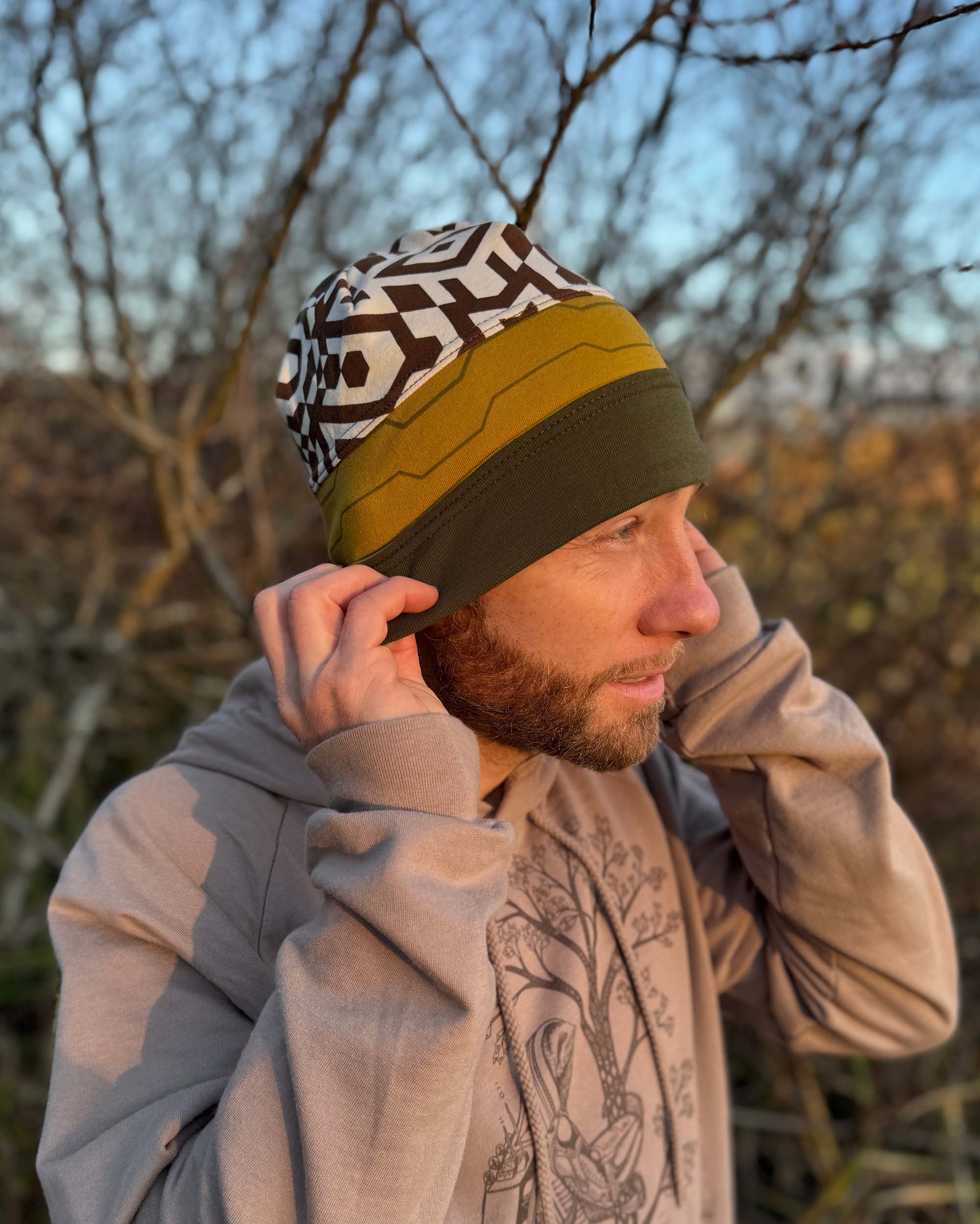 Organic cotton beanie, undyed, yellow and green colored fabric, right side on male model in natural lighting.