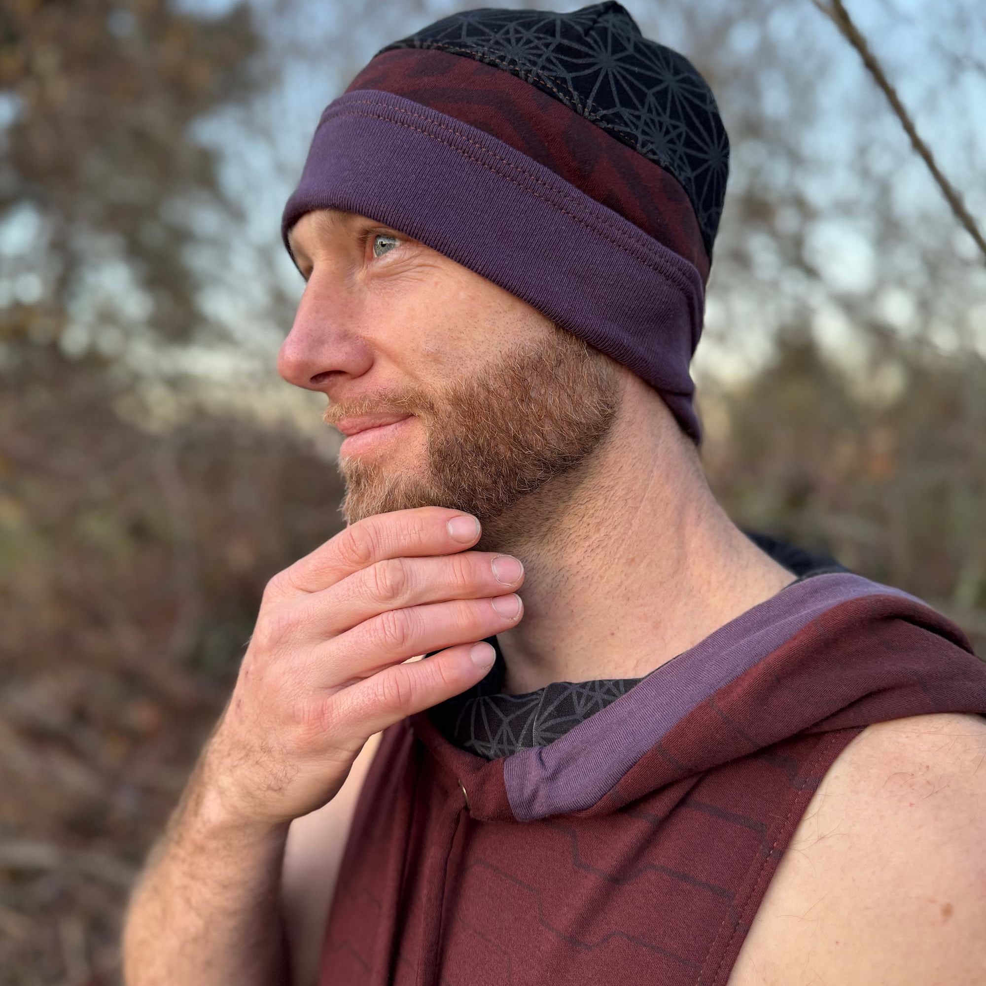 Organic cotton beanie, black and brown with geometric printed fabric, left side view on male model.