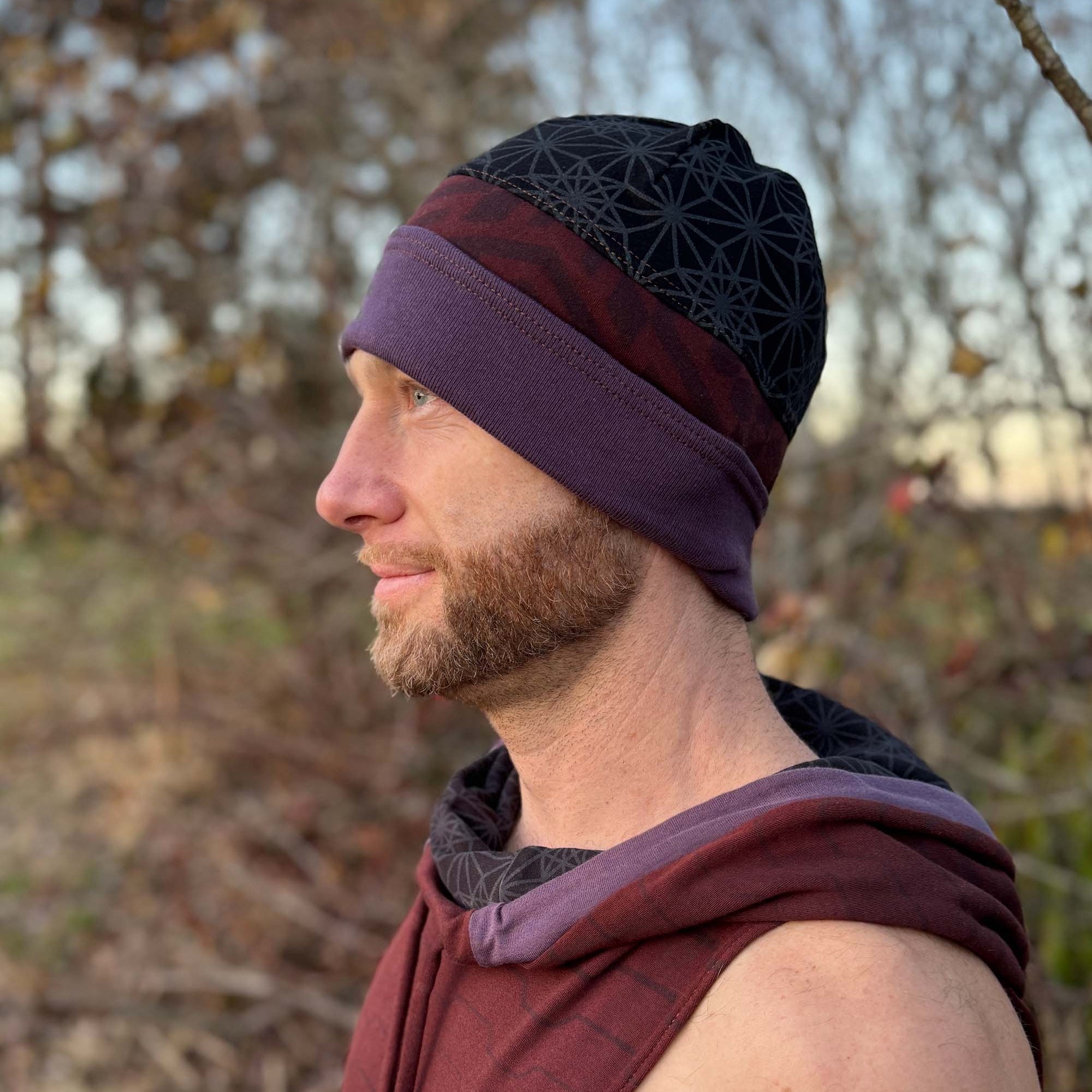 Organic cotton beanie, black and brown with geometric printed fabric, left profile view on male model.