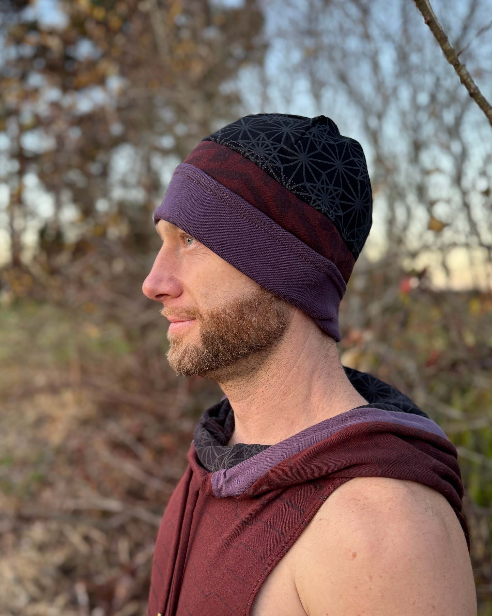 Organic cotton beanie, black and brown with geometric printed fabric, left profile view on male model.