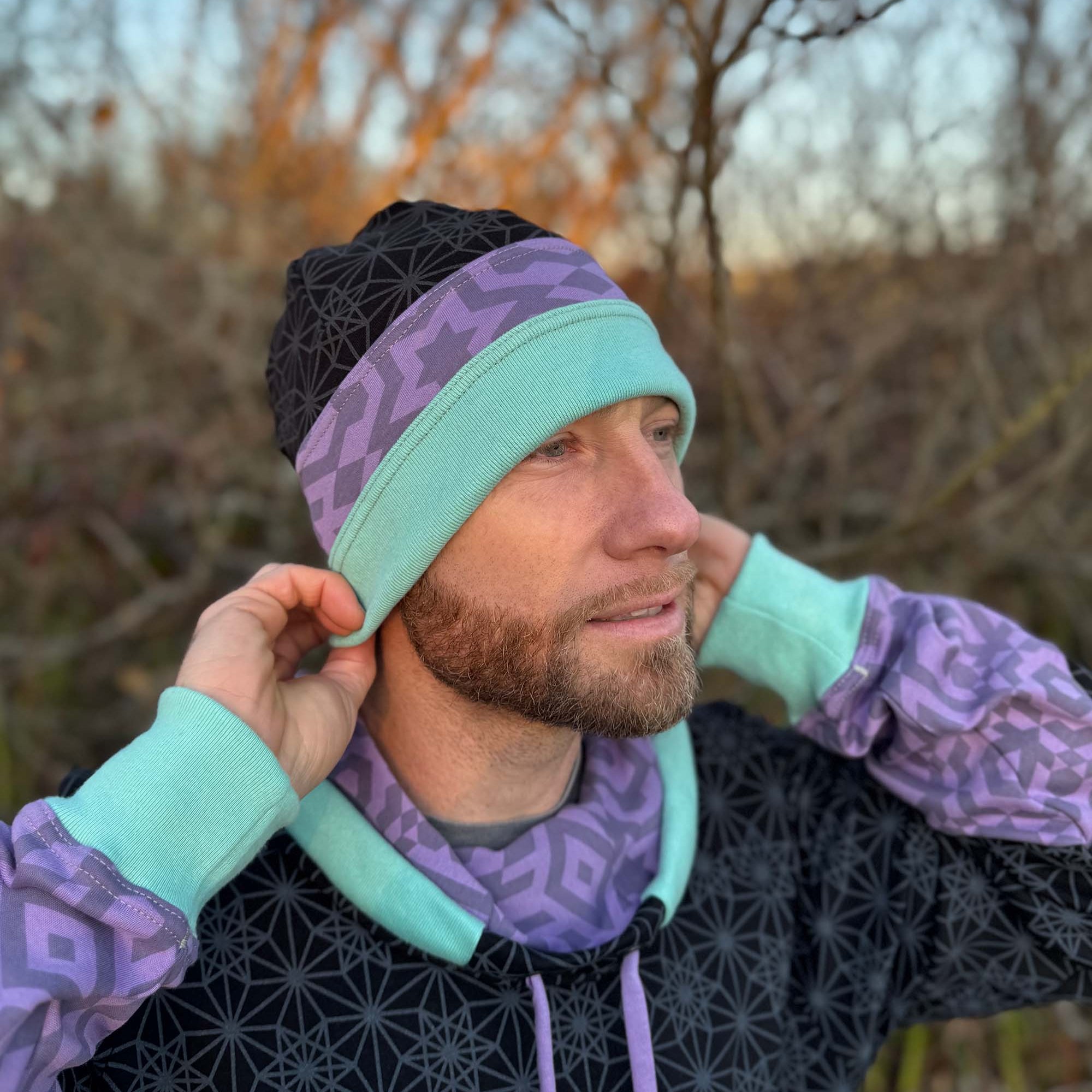 Organic cotton beanie, black, lavender and green accent fabric, front right view on male model.