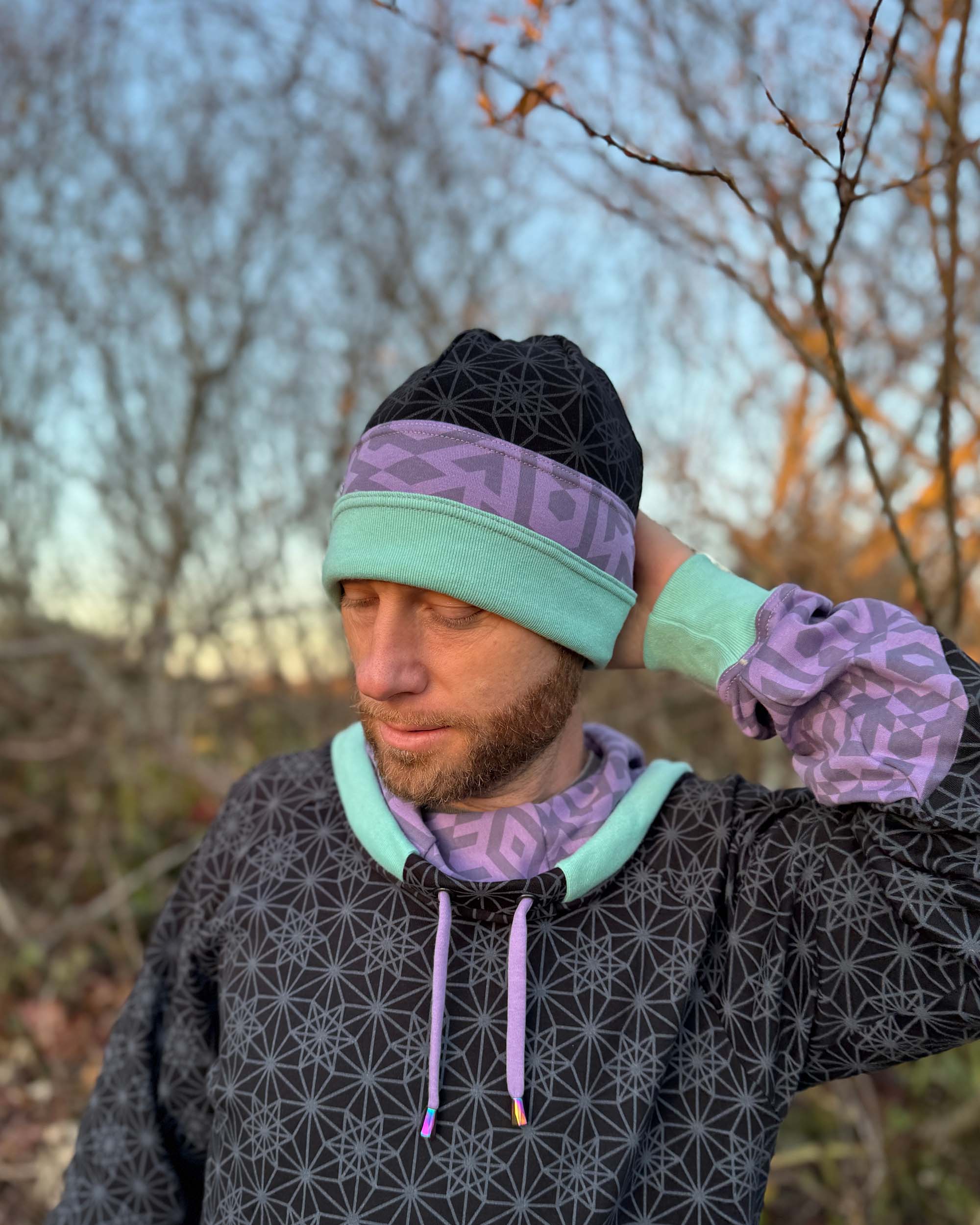 Organic cotton beanie, black, lavender and green accent fabric, front left view on male model.