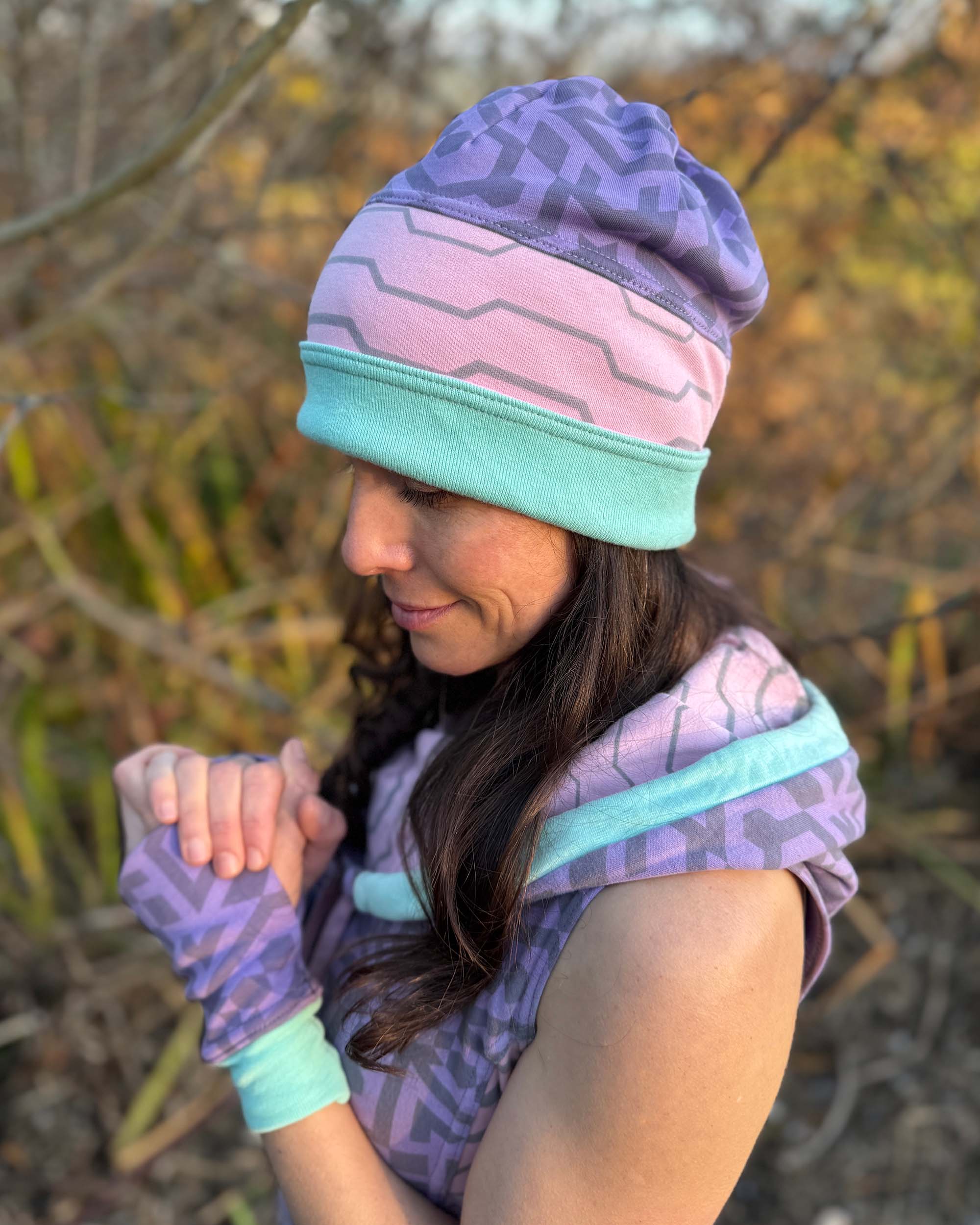 Organic cotton beanie, pink and lavender with geometric printed fabric, left side view on female model.