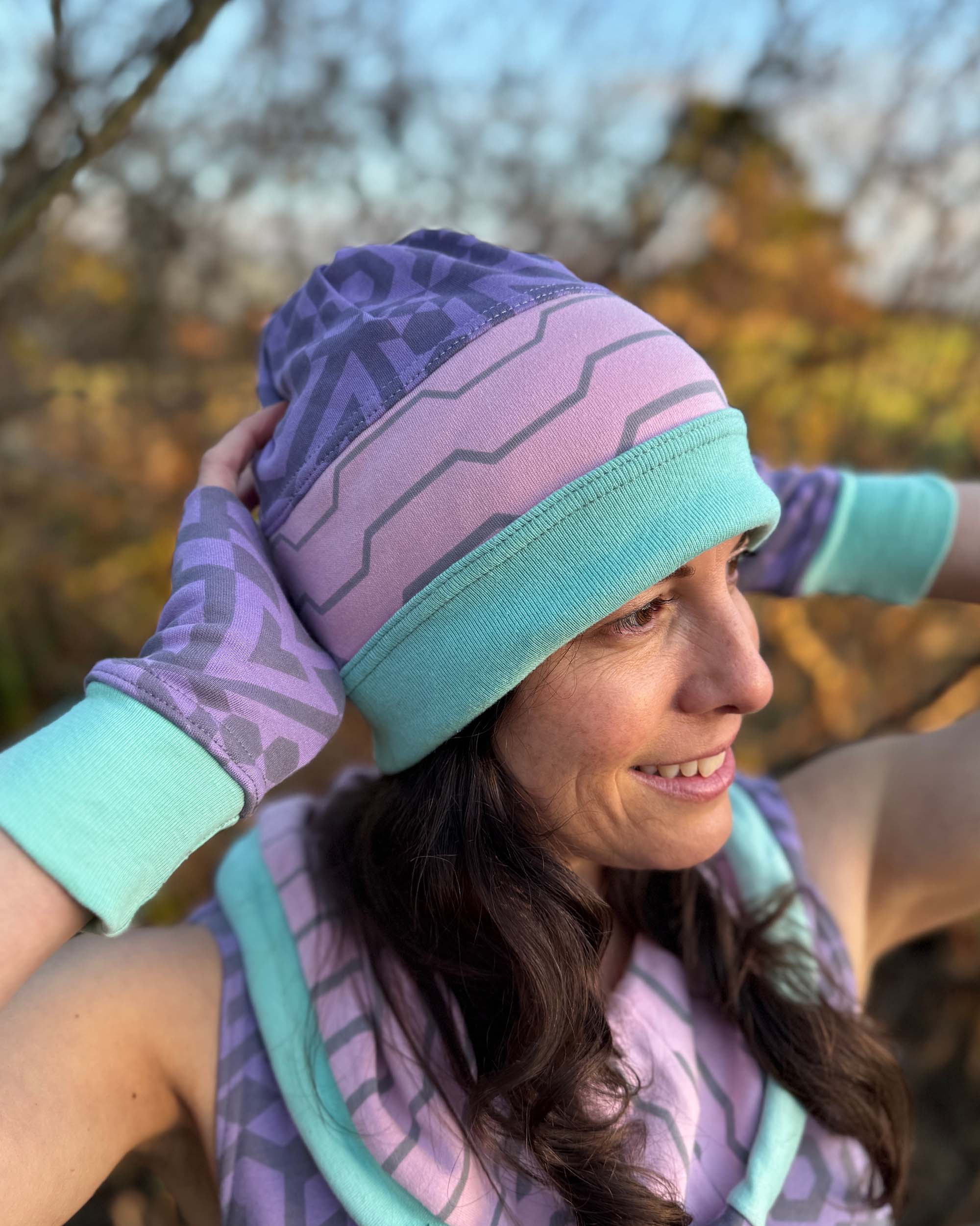 Organic cotton beanie, pink and lavender with geometric printed fabric, right side view on female model.