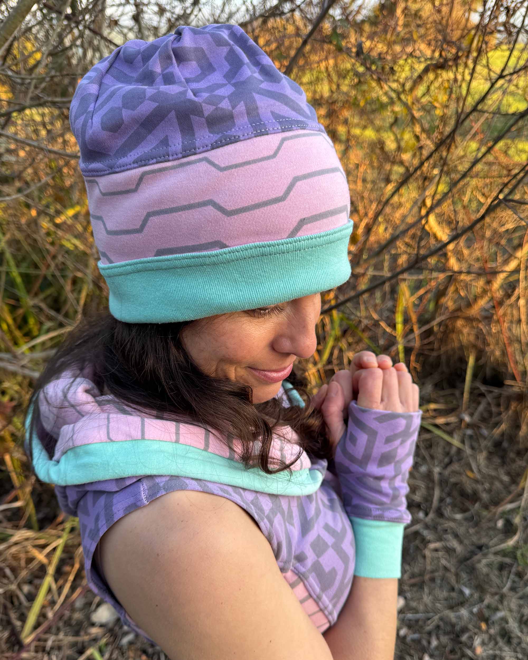 Organic cotton beanie, pink and lavender with geometric printed fabric, left view on female model.