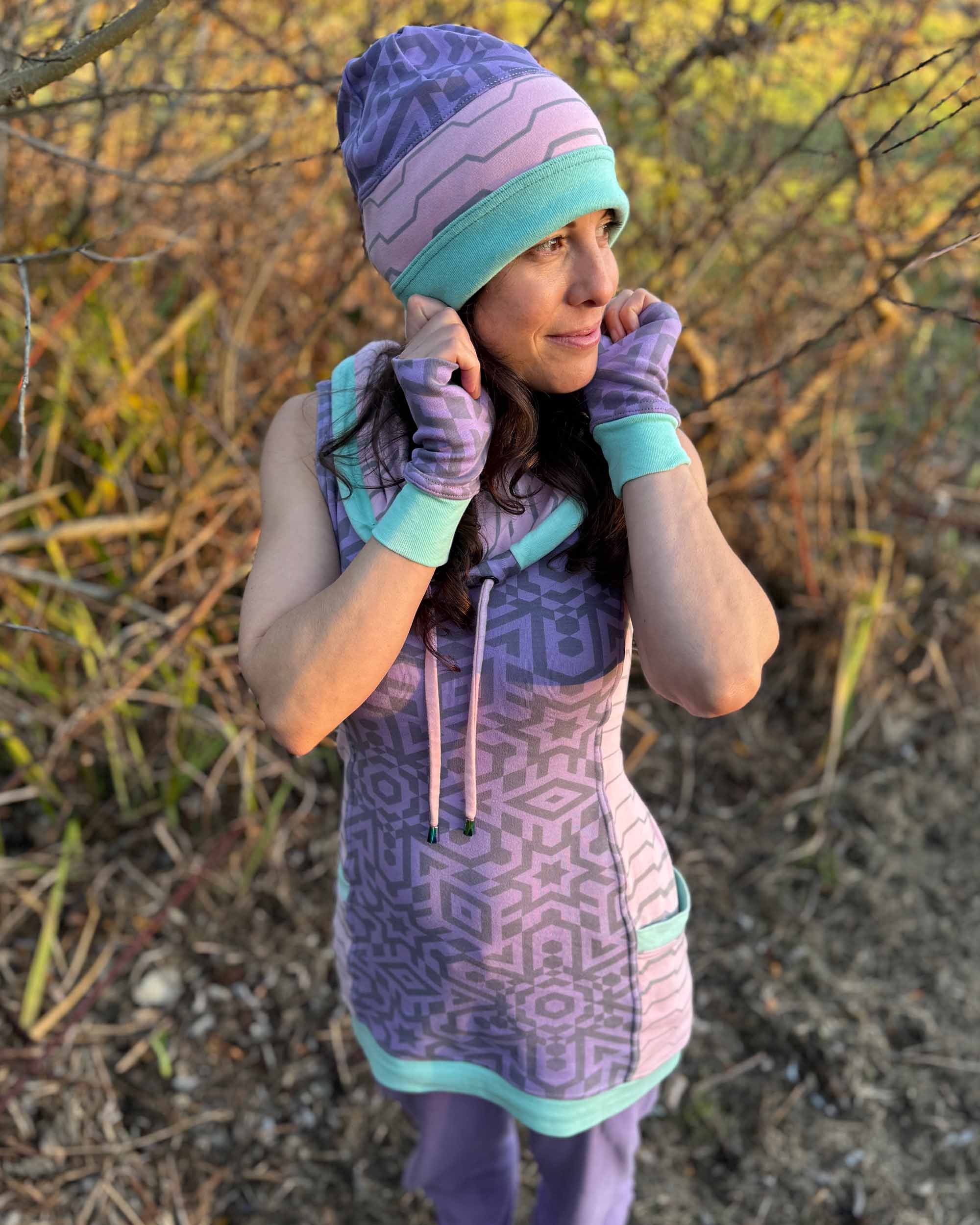 Organic cotton beanie, pink and lavender with geometric printed fabric, left side full body view on female model.