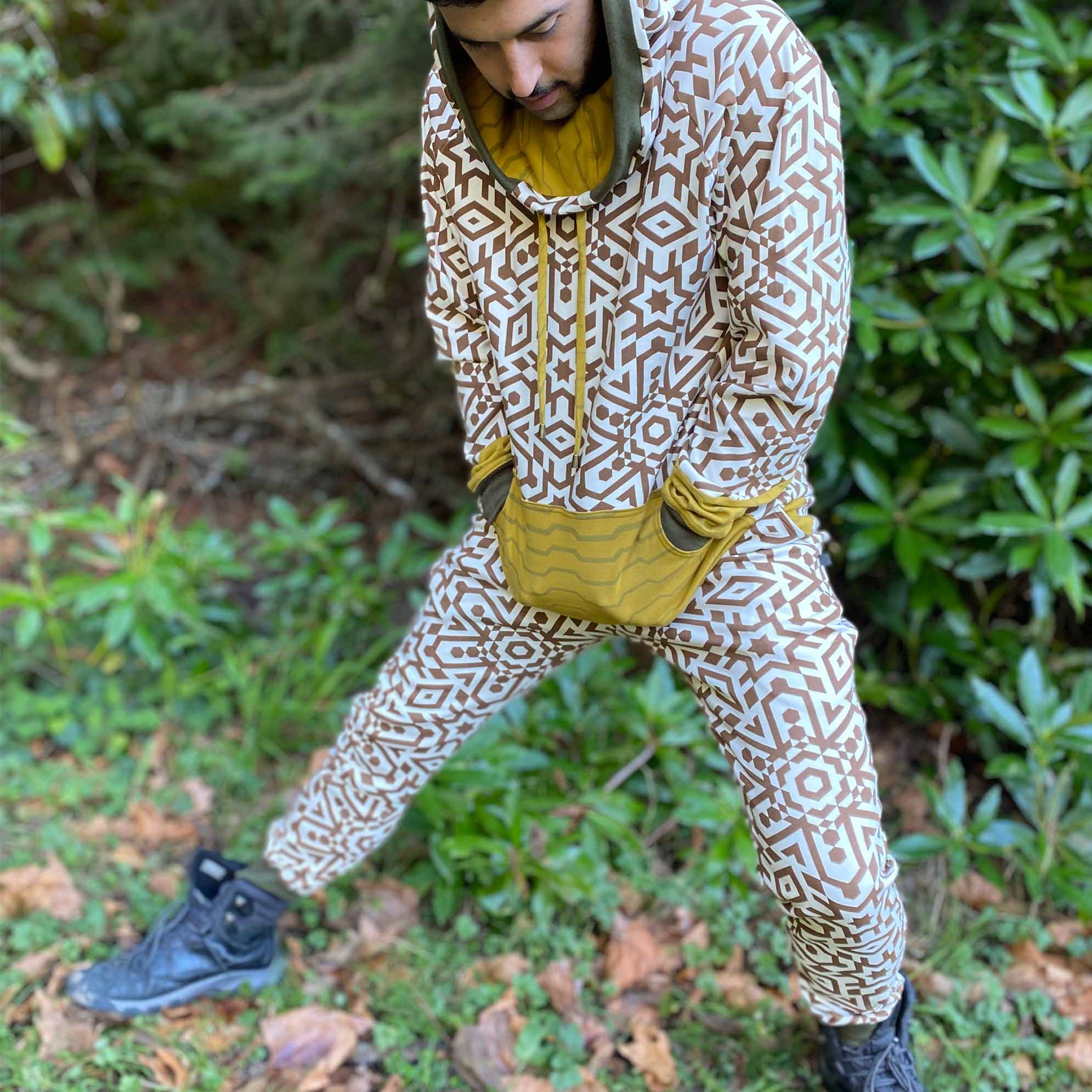 Men's matching two piece sweatsuit, brown geometric print organic fabric, front view, worn on male model.