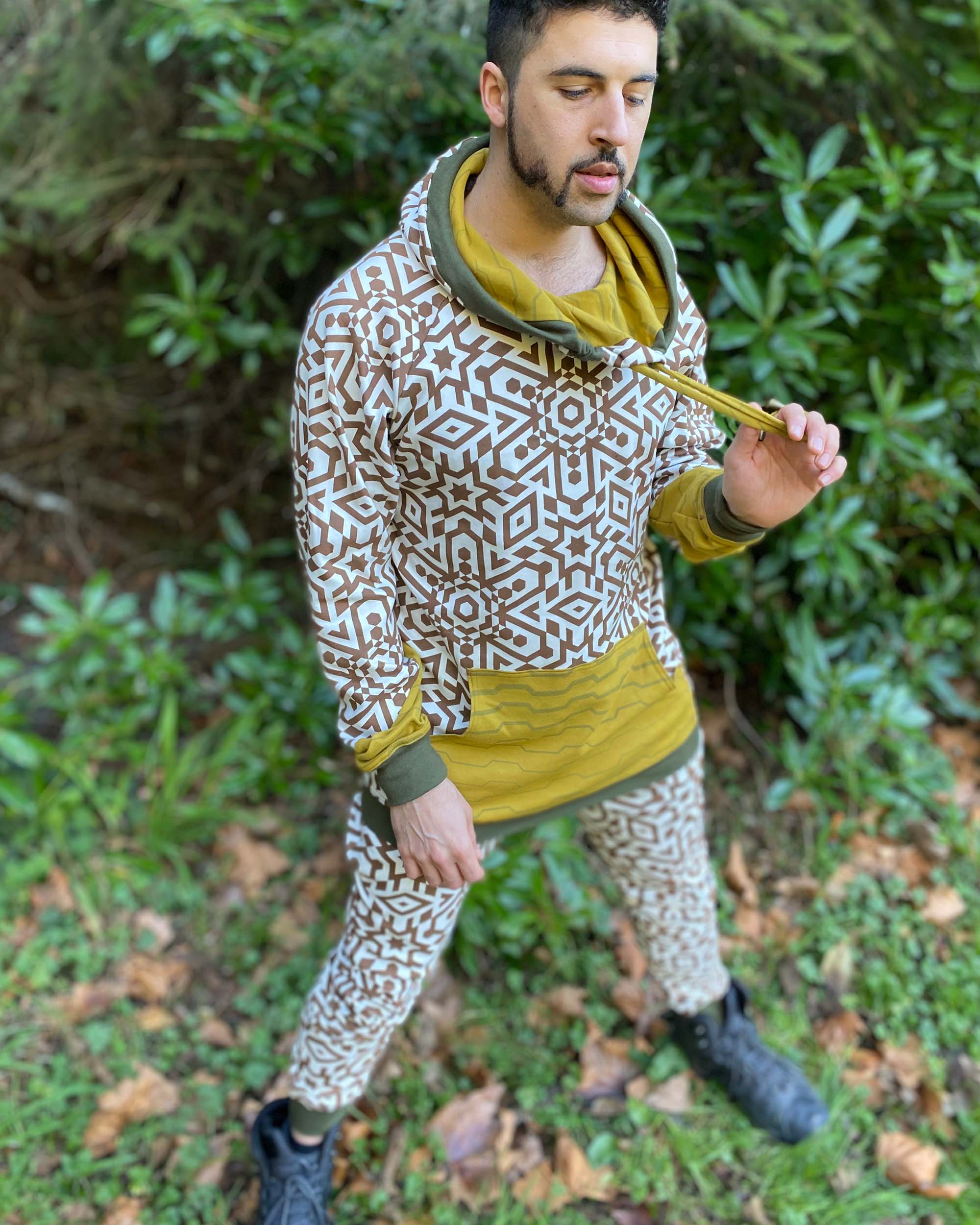 Men's matching two piece sweatsuit, brown geo printed organic fabric, right side view, worn on male model.