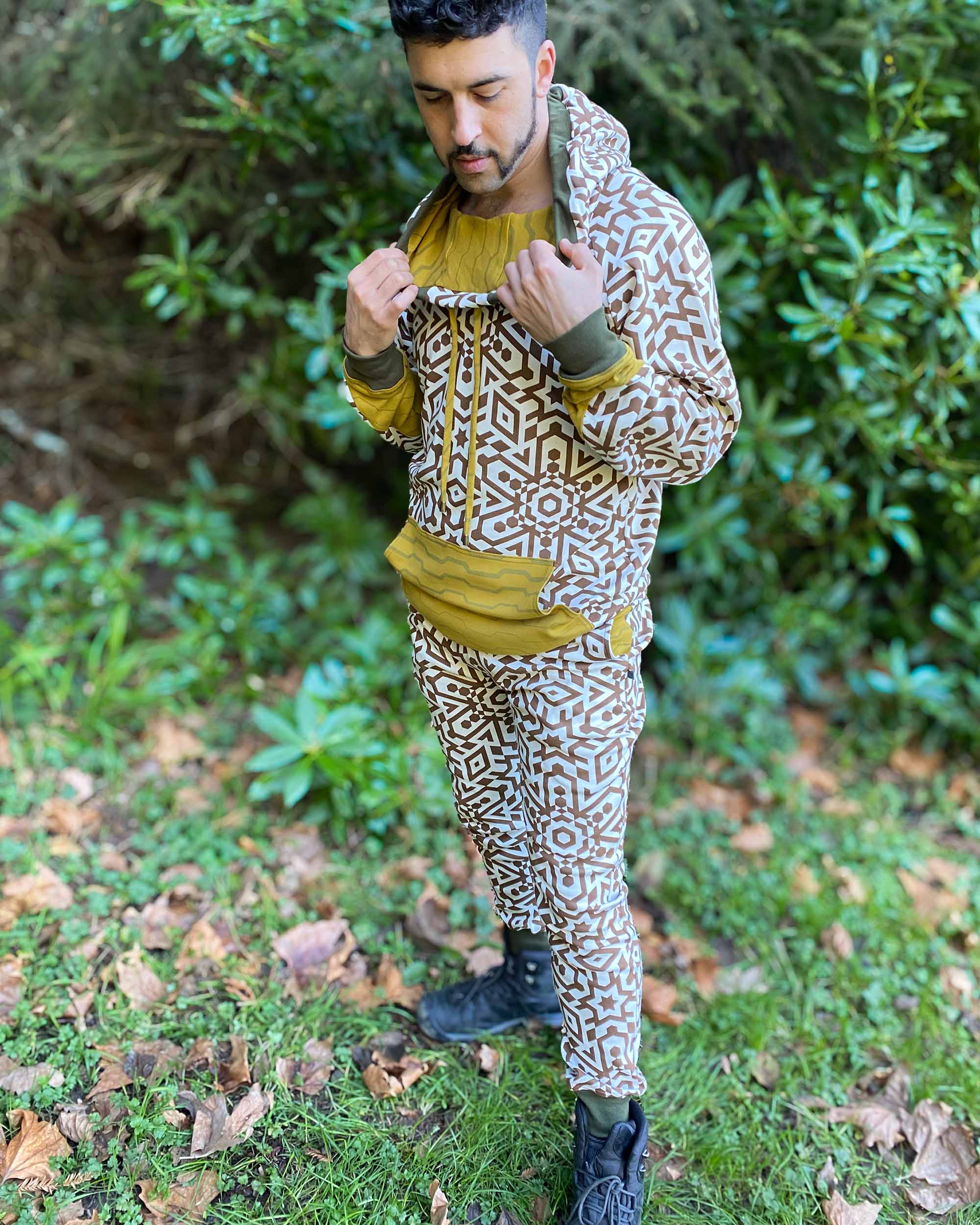 Men's matching two piece sweatsuit, brown geo printed organic fabric, left side view, worn on male model.