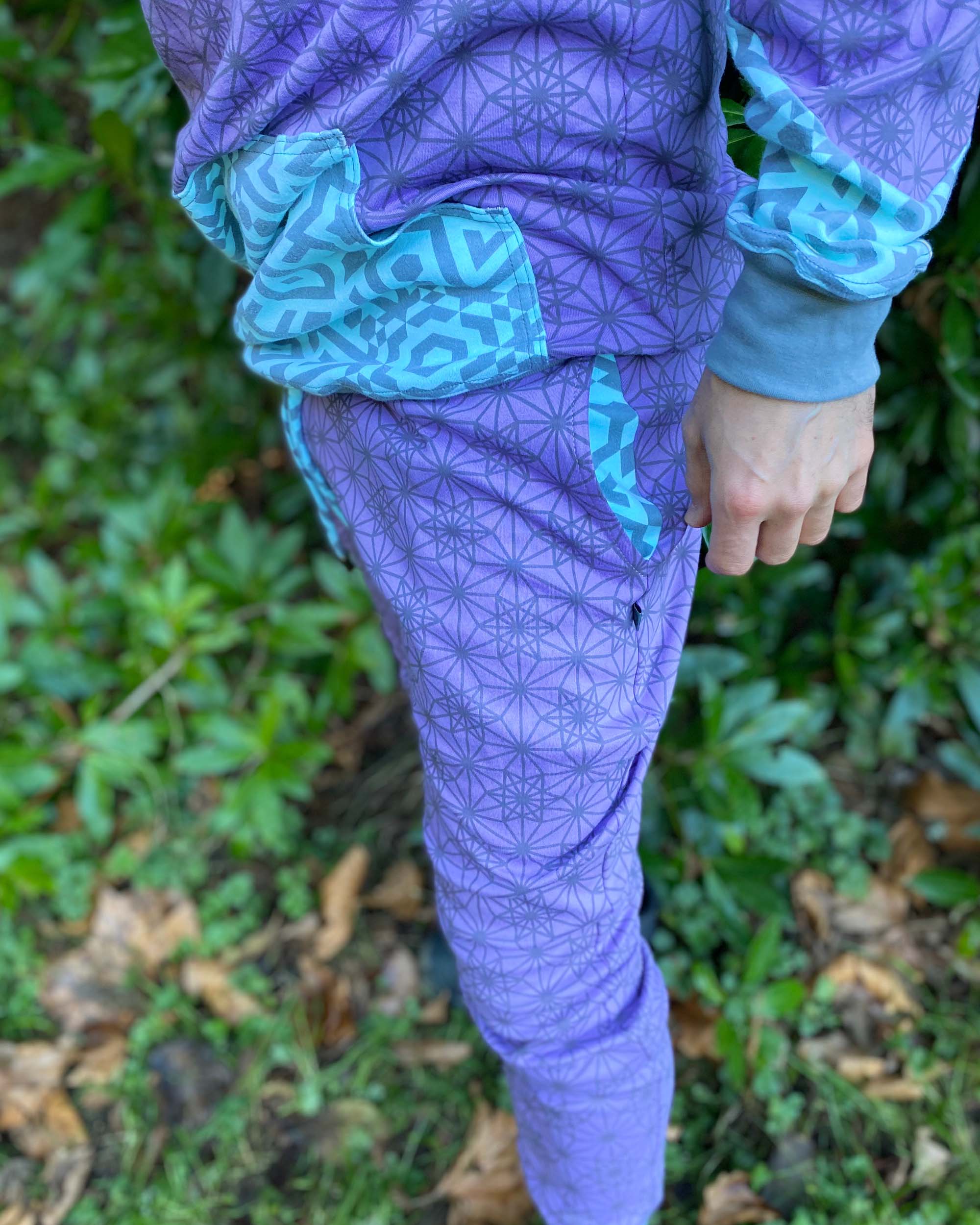 Men's matching two piece sweatsuit, lavender fabric with geometric print, front detail view of fabric.