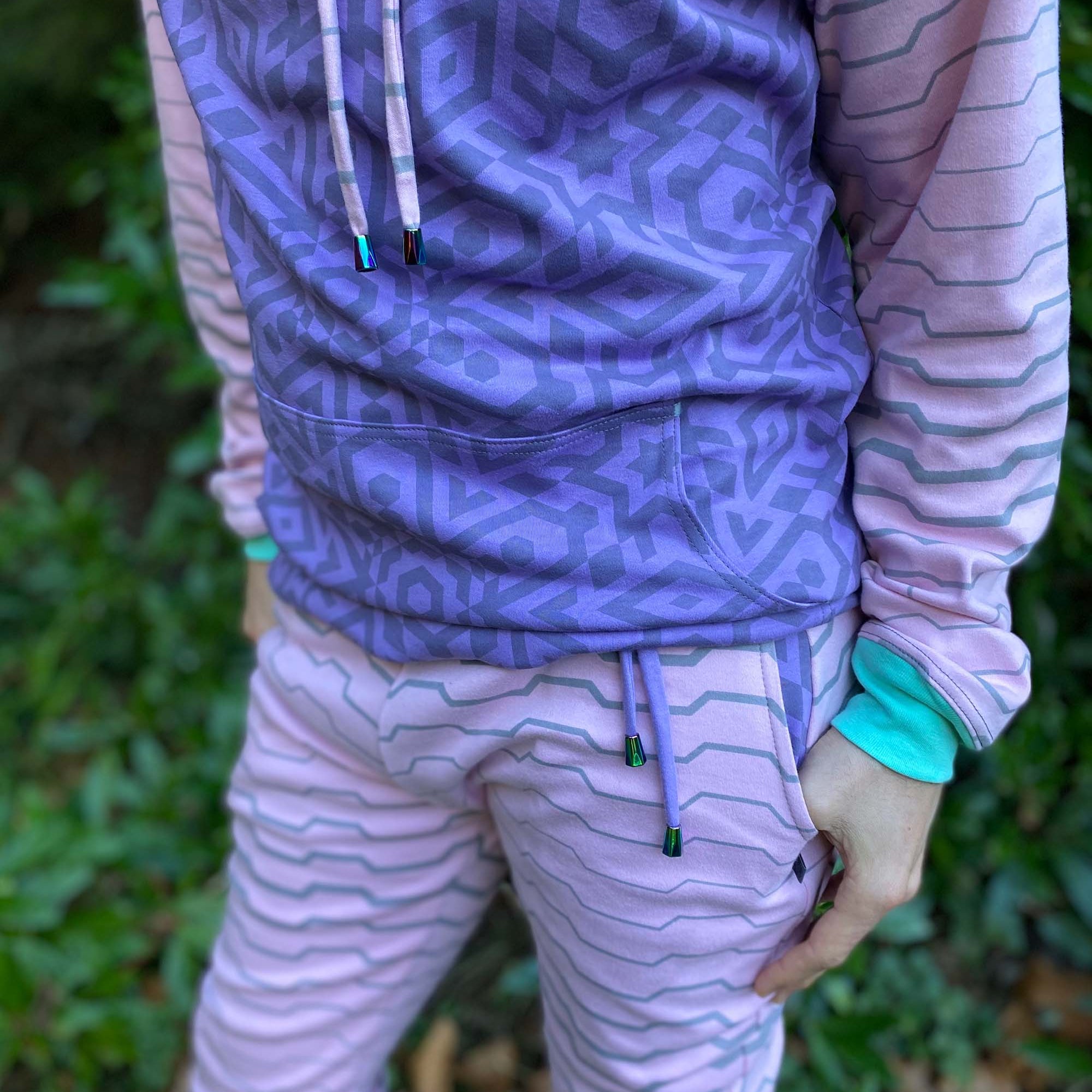 Men's matching two piece sweatsuit, pink and purple fabric, geometric print, detail view of pockets.