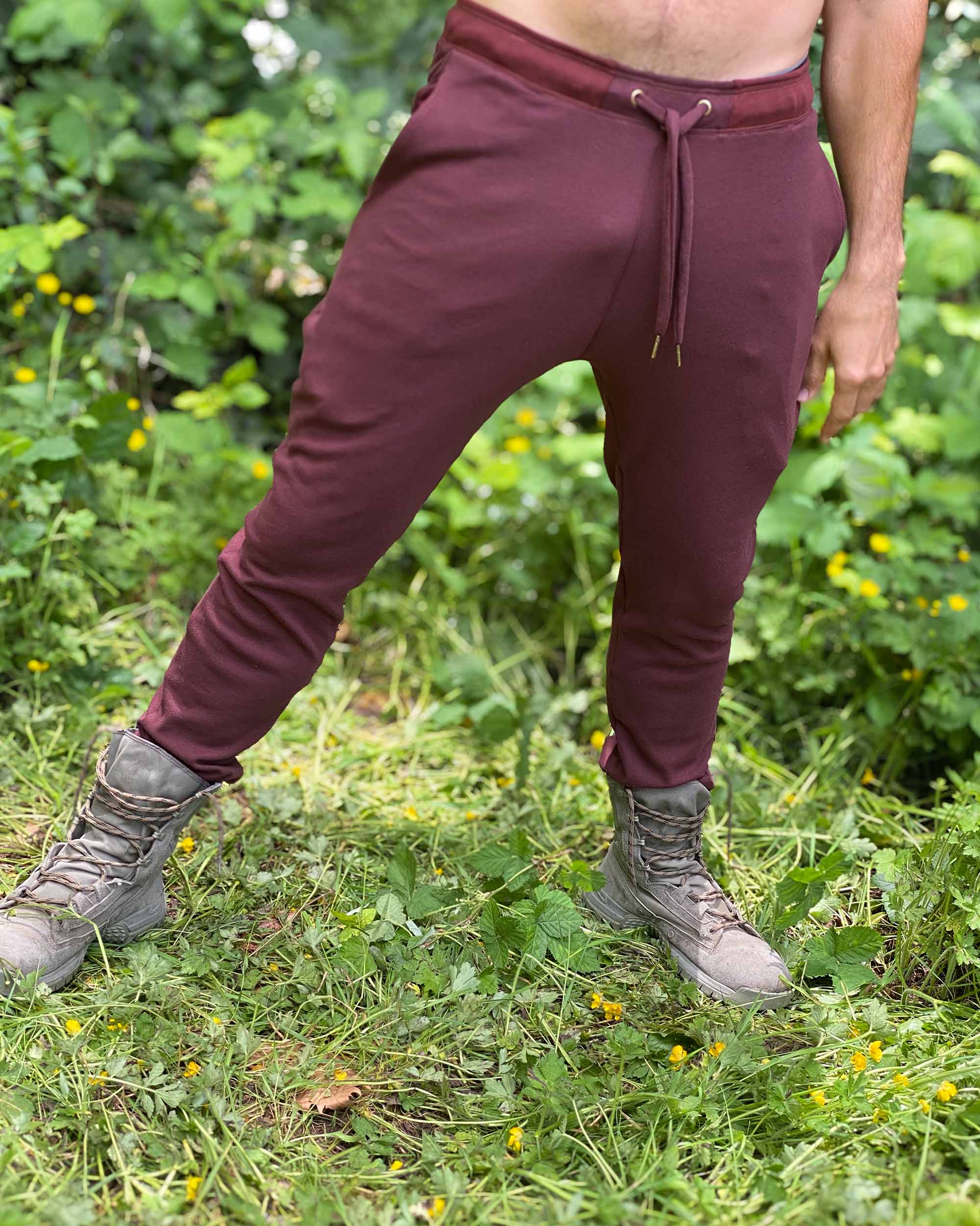 Organic cotton unisex joggers, reddish brown fabric, right side view on male model in nature.