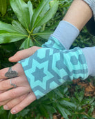 Organic cotton hand warmers mint colored fabric with geometric print, left hand detail view.