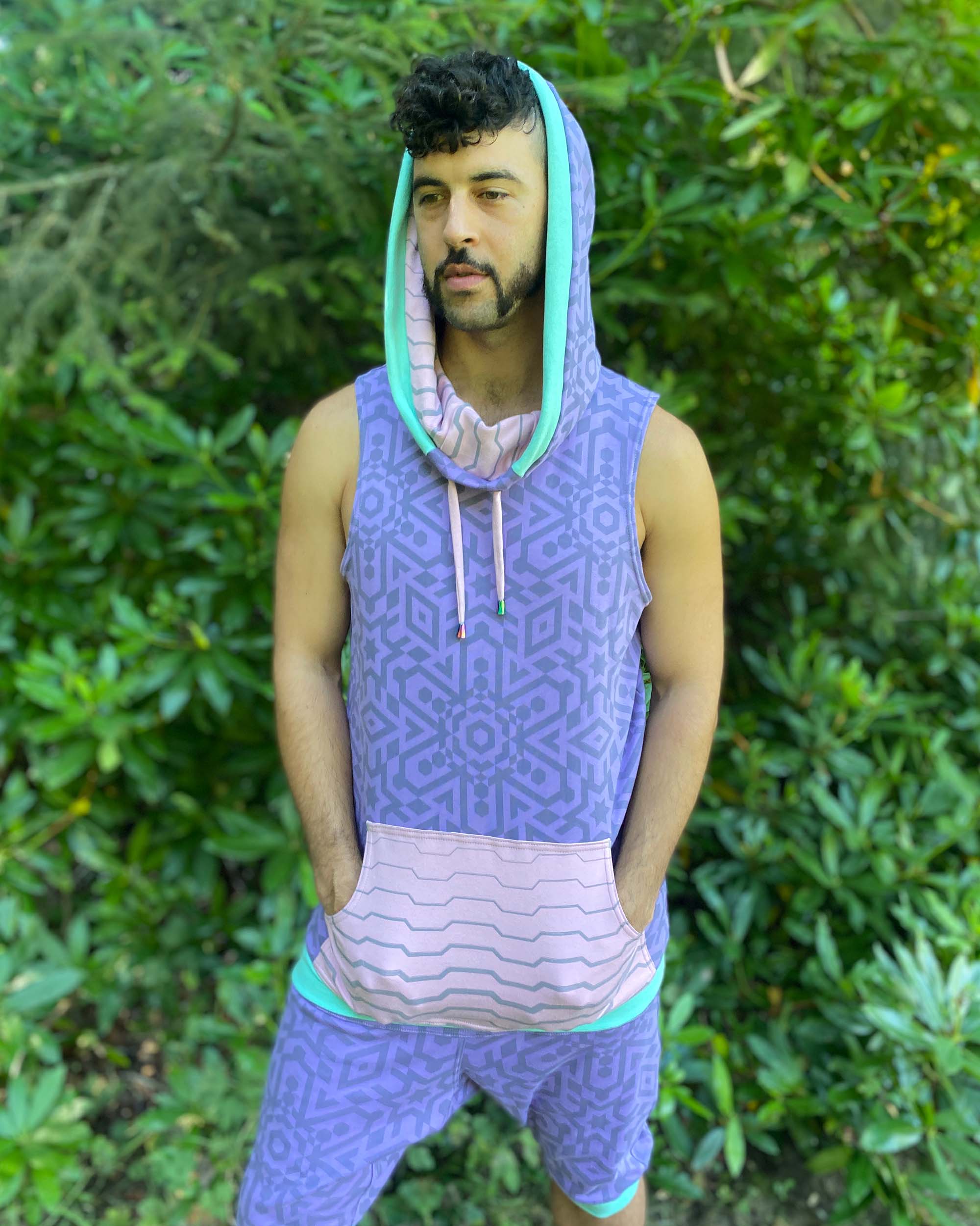 Organic cotton hooded tank top and shorts, lavender fabric with geometric print, front left side view on model.