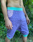 Organic cotton drop crotch shorts, lavender fabric with geometric print, front right side view on model.