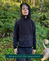 Organic cotton youth fleece hoodie, black  with geometric printed sleeves, worn by a boy in nature.