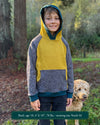 Organic cotton fleece kids hoodie, yellow and grey fabric with geometric print, worn by a boy.