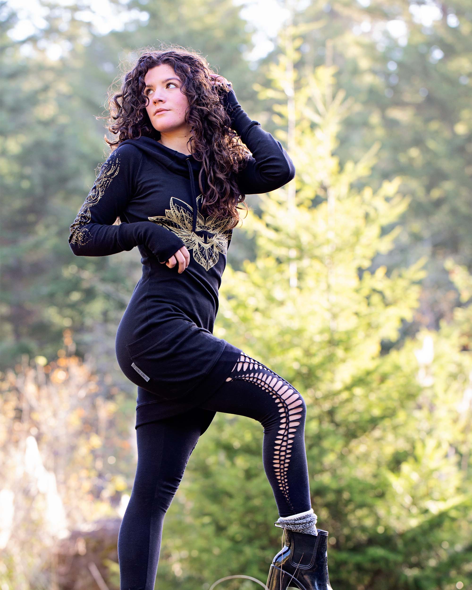 Organic cotton long sleeve tunic dress, black with front gold lotus print, full length side view on female model.
