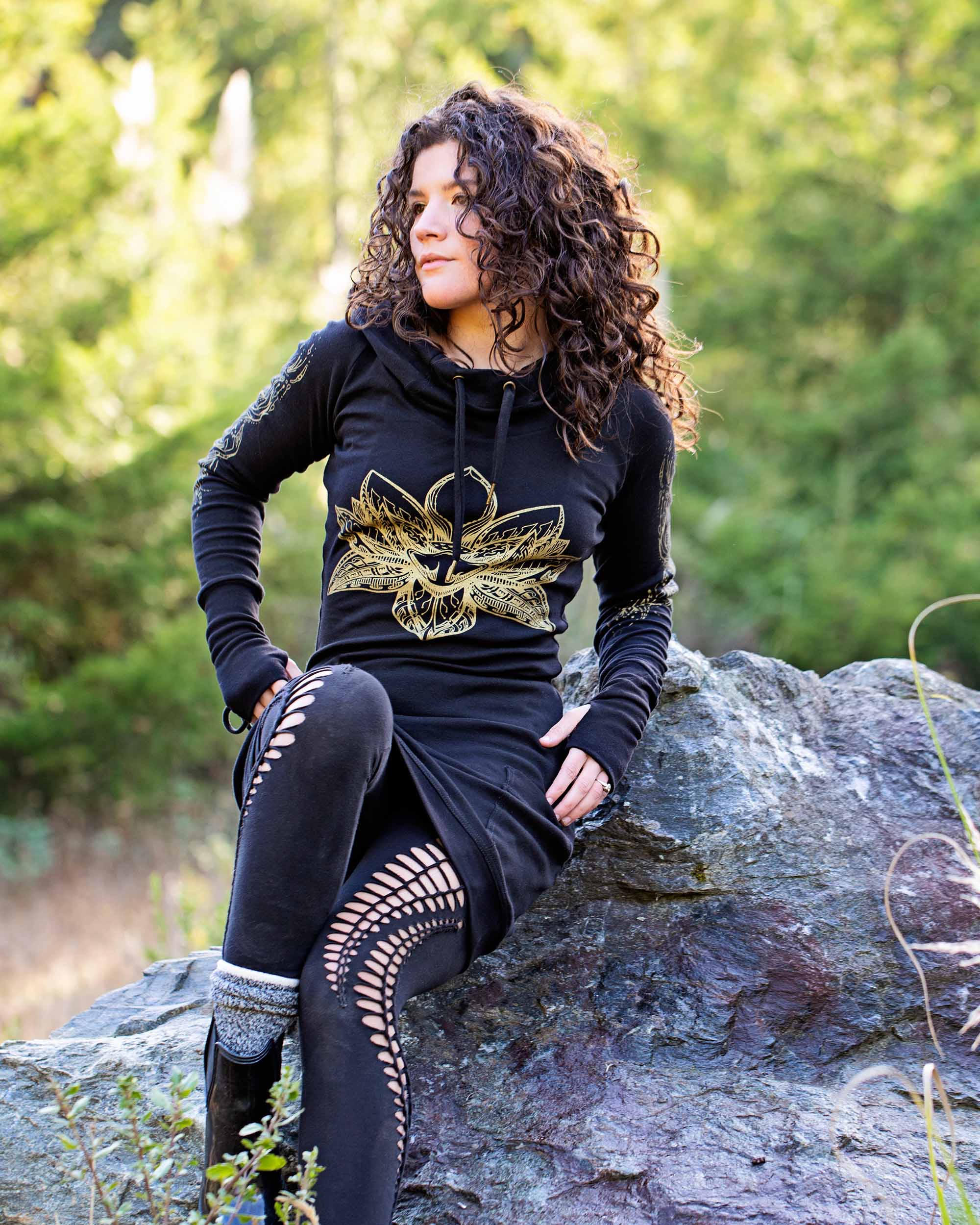 Organic cotton long sleeve tunic dress, black with front gold lotus print, full length front view of lounging female model.