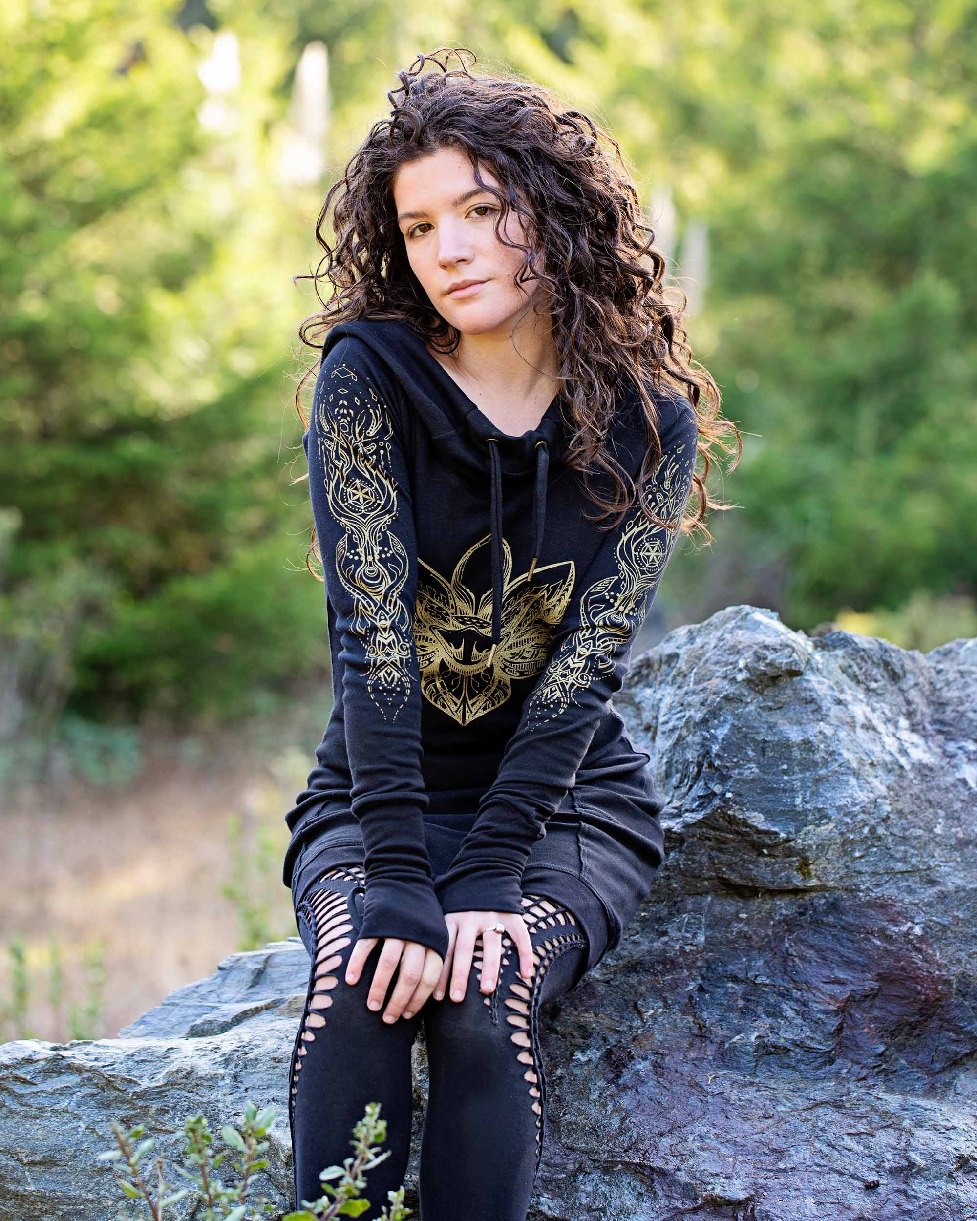 Organic cotton long sleeve tunic dress, black with front gold lotus print, front view of sitting female model.