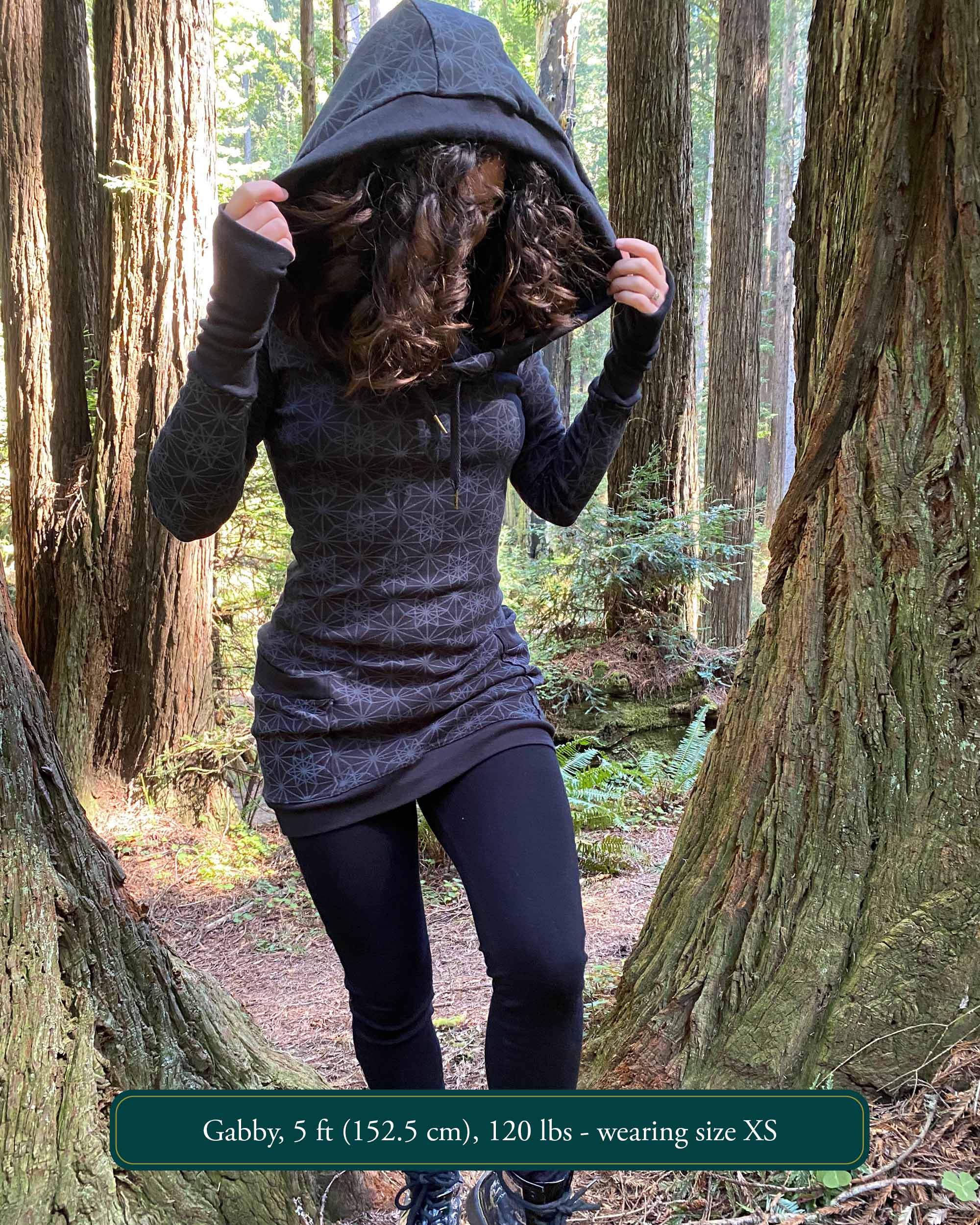 Organic cotton hooded long sleeve dress, black with geometric print, front view on female model.