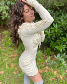 Organic cotton long sleeve tunic dress, undyed fabric with front gold lotus print, right side view worn by female model.