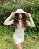 Organic cotton long sleeve tunic dress, undyed fabric with front gold lotus print, worn by female model with hood up.