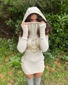 Organic cotton fitted tunic dress, undyed fabric with gold lotus design, natural lighting front view.