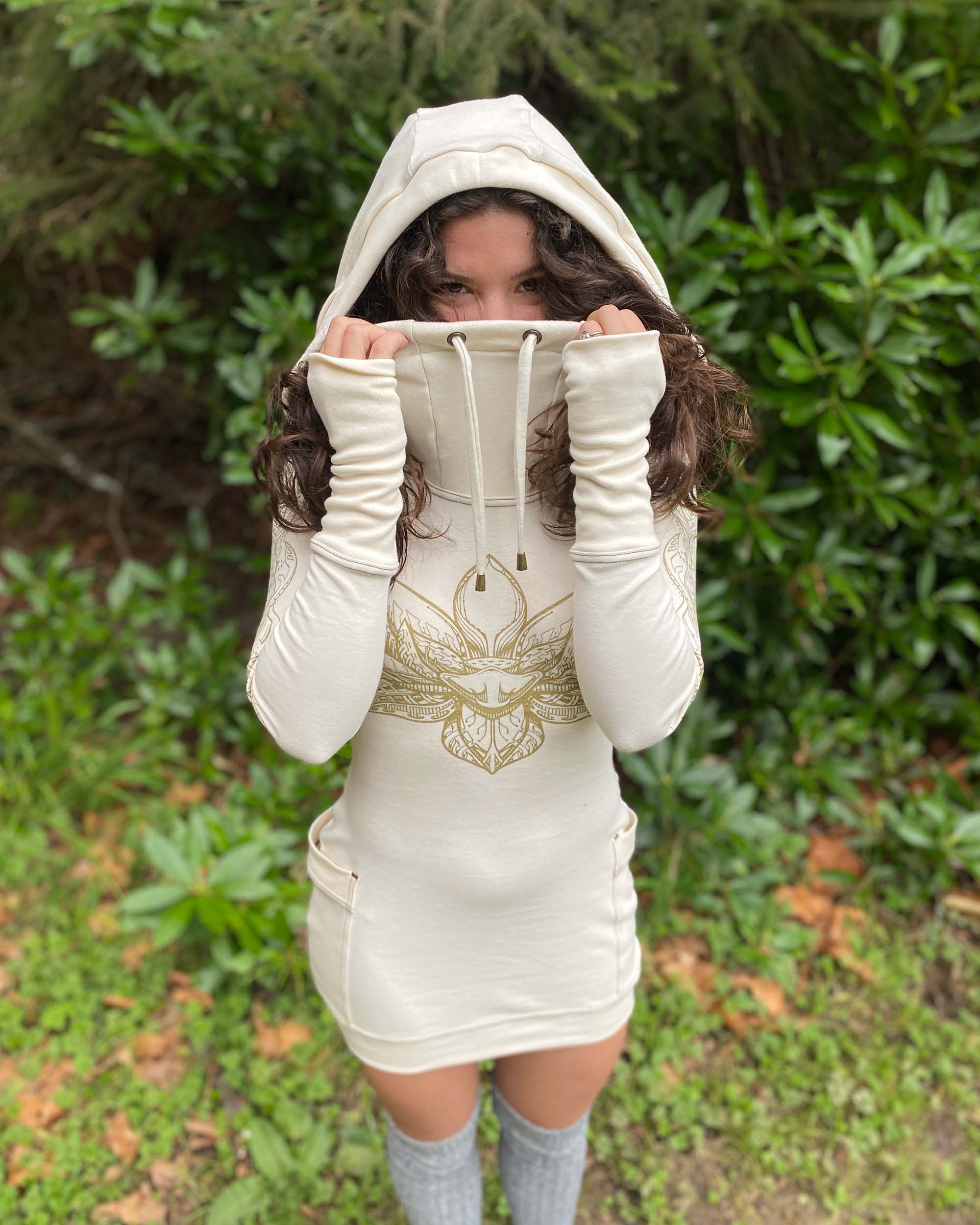 Organic cotton fitted tunic dress, undyed fabric with gold lotus design, natural lighting front view.