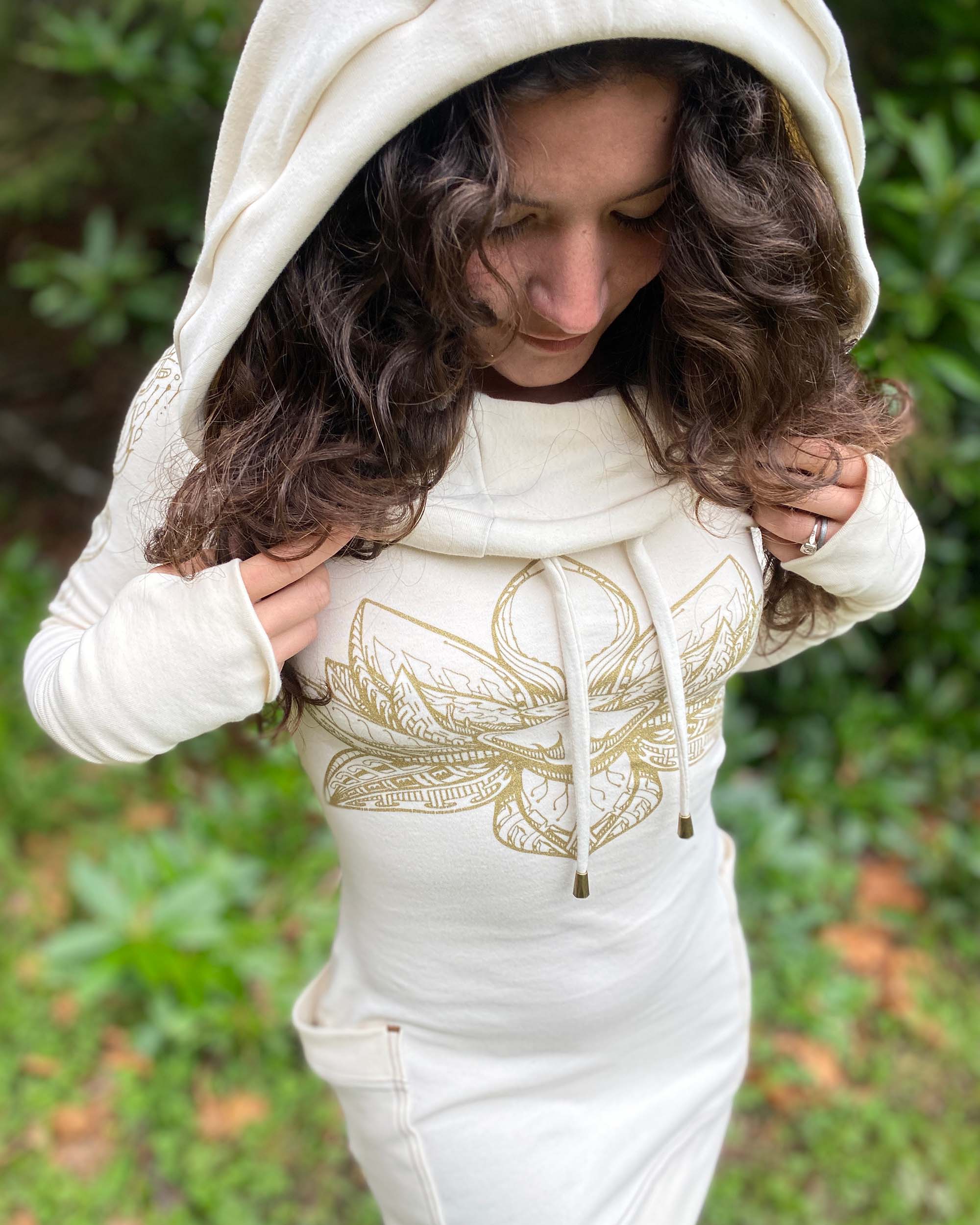 Organic cotton long sleeve tunic dress, undyed fabric with gold lotus design, detail of chest print on female model.