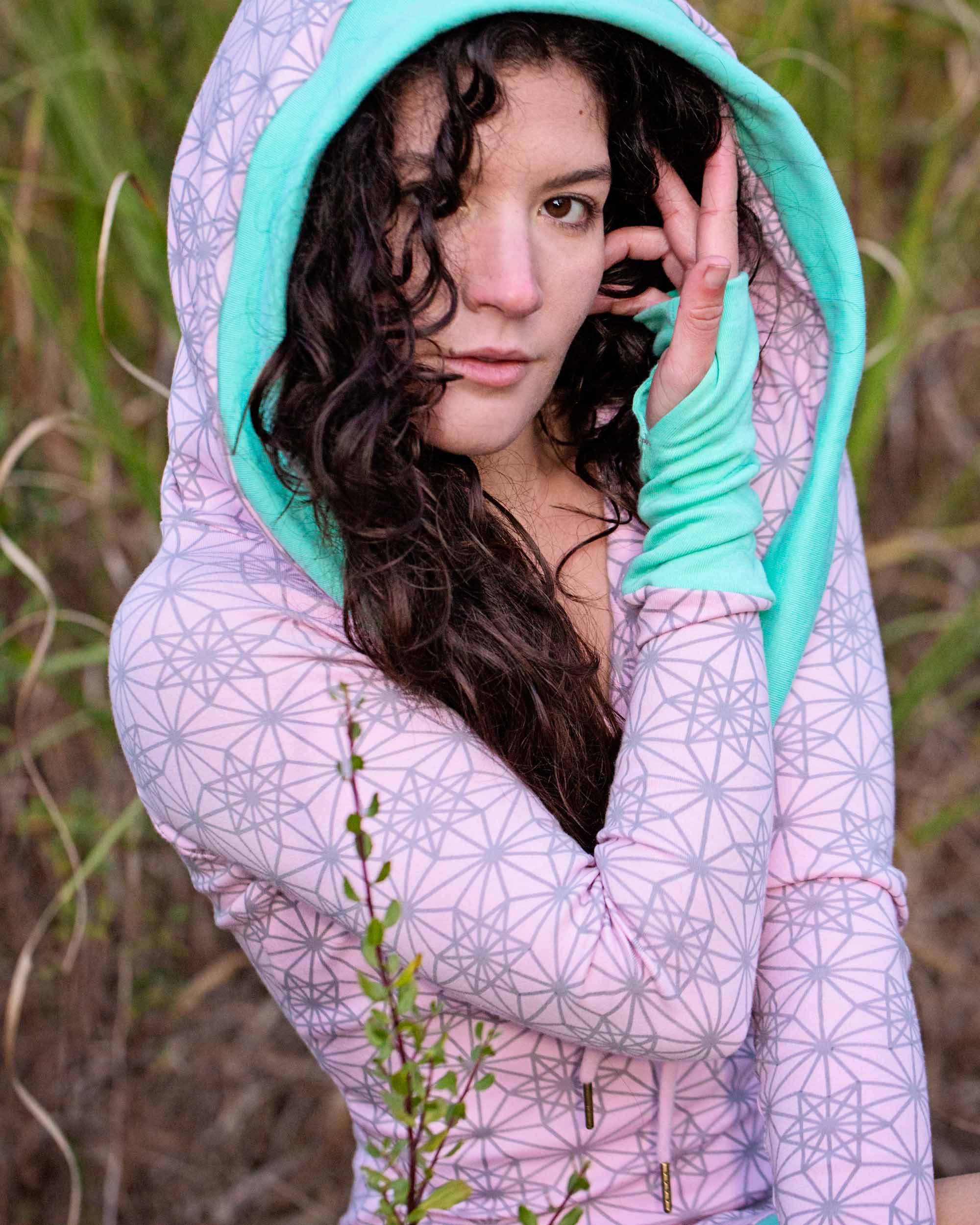 Organic cotton fitted tunic dress, pink with green accent fabric, detail view of female with hood up.