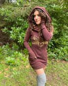 Organic cotton long sleeve tunic dress, brown with front gold lotus print, front view on female model with hood up.