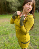 Organic cotton long sleeve tunic dress, yellow with green accent fabric, side view on female model.