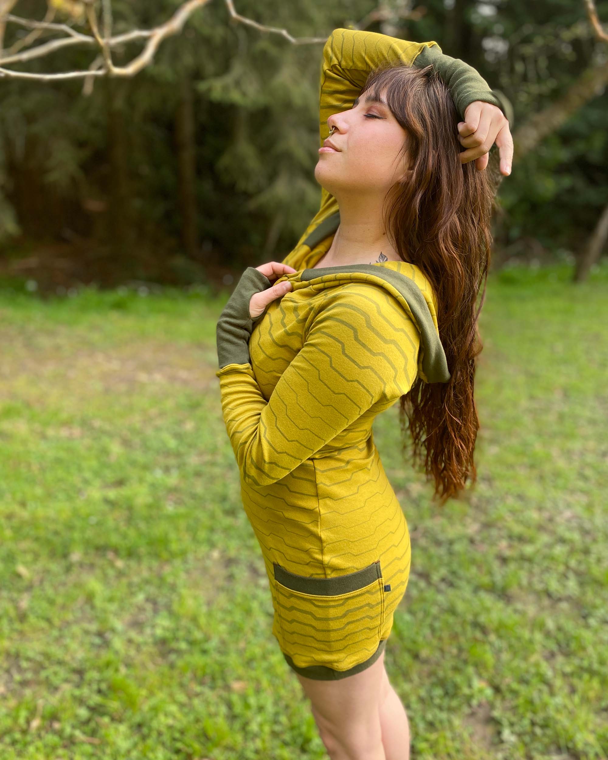 Organic cotton long sleeve tunic dress, yellow with green accent fabric, full length side view on female model.