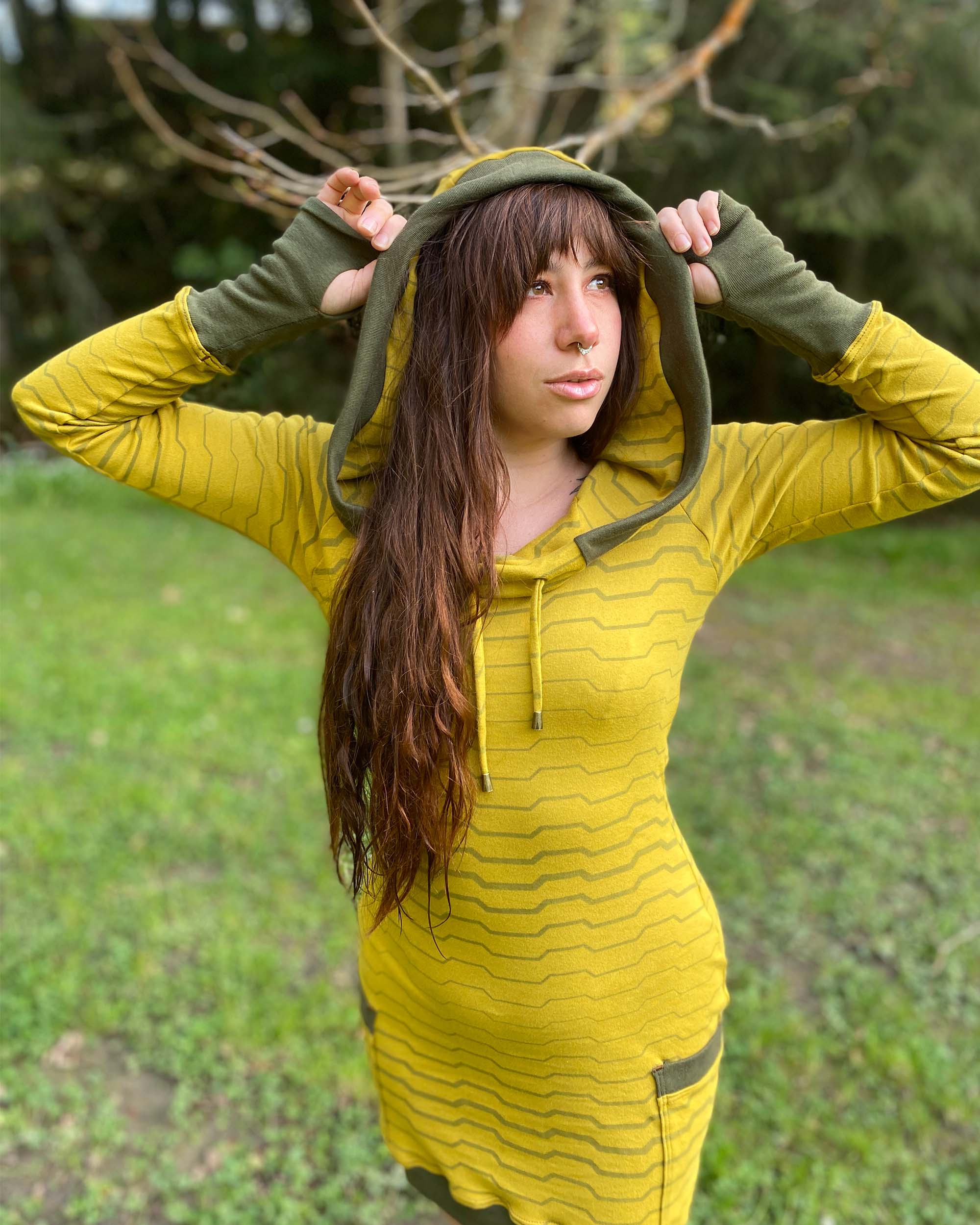 Organic cotton long sleeve tunic dress, yellow with green accent fabric, front view on female model, hood up.