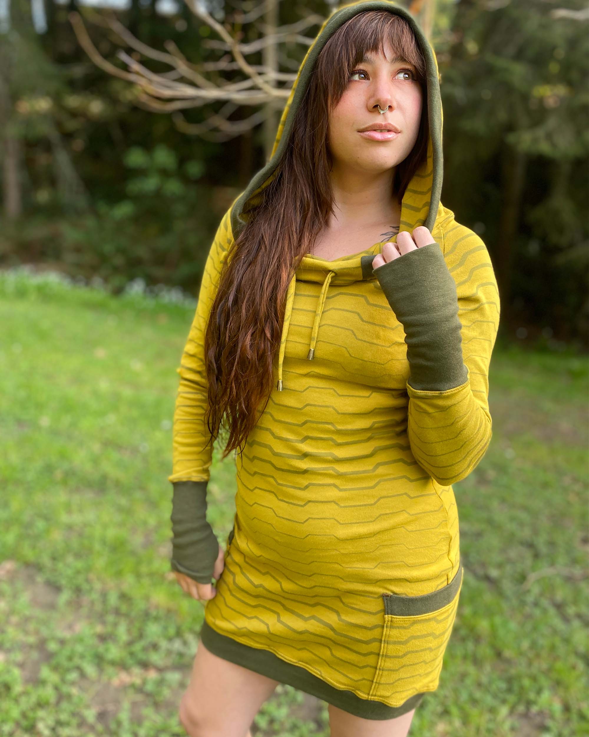 Organic cotton long sleeve tunic dress, yellow with green accent fabric, front view on female model in nature.