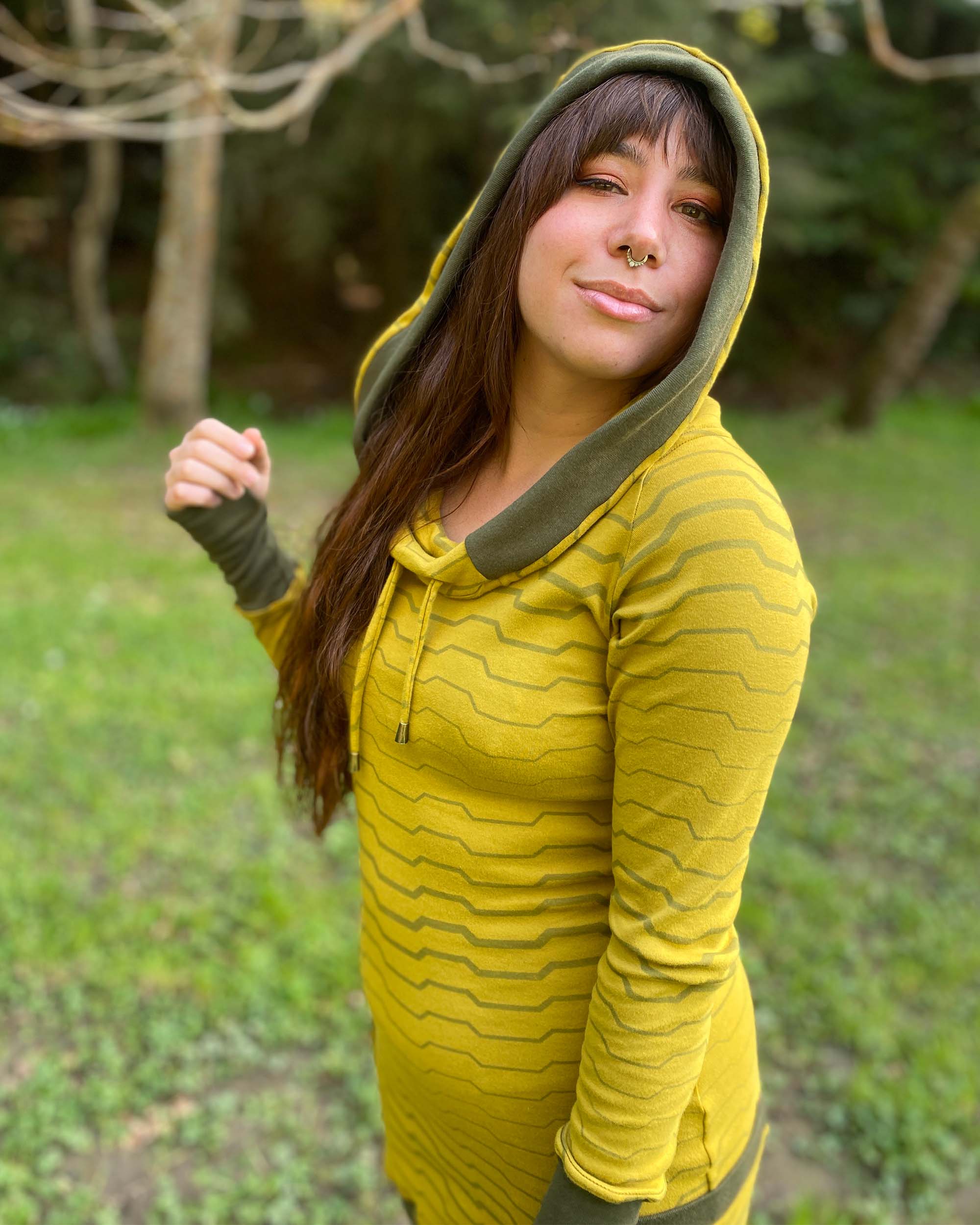 Organic cotton long sleeve tunic dress, yellow with green accent fabric, close up view of model with hood up.