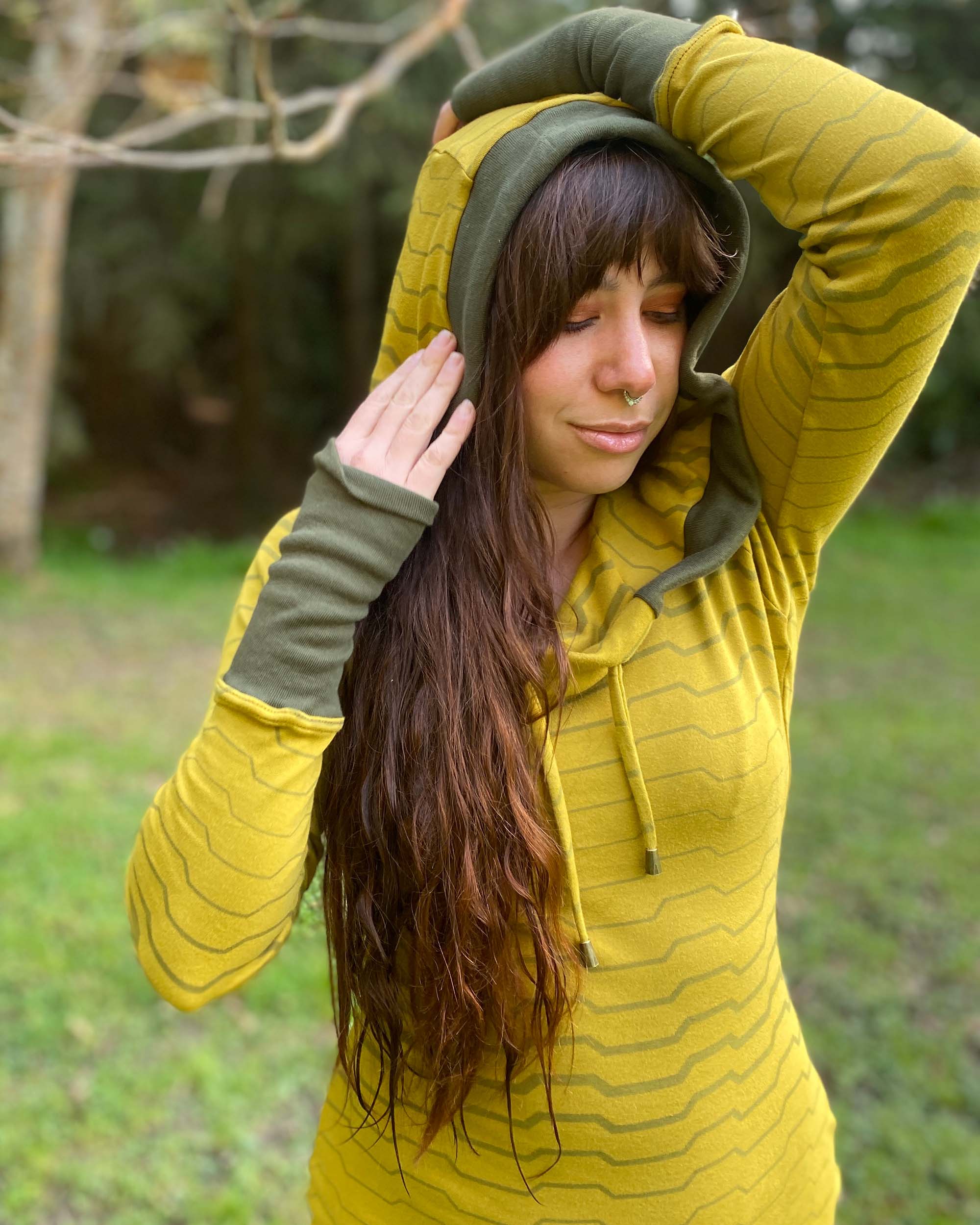 Organic cotton long sleeve tunic dress, yellow with green accent fabric, front detail view of female model.