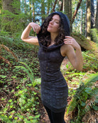 Organic cotton sleeveless tunic dress, black fabric with sacred geometry print, side view on female model.